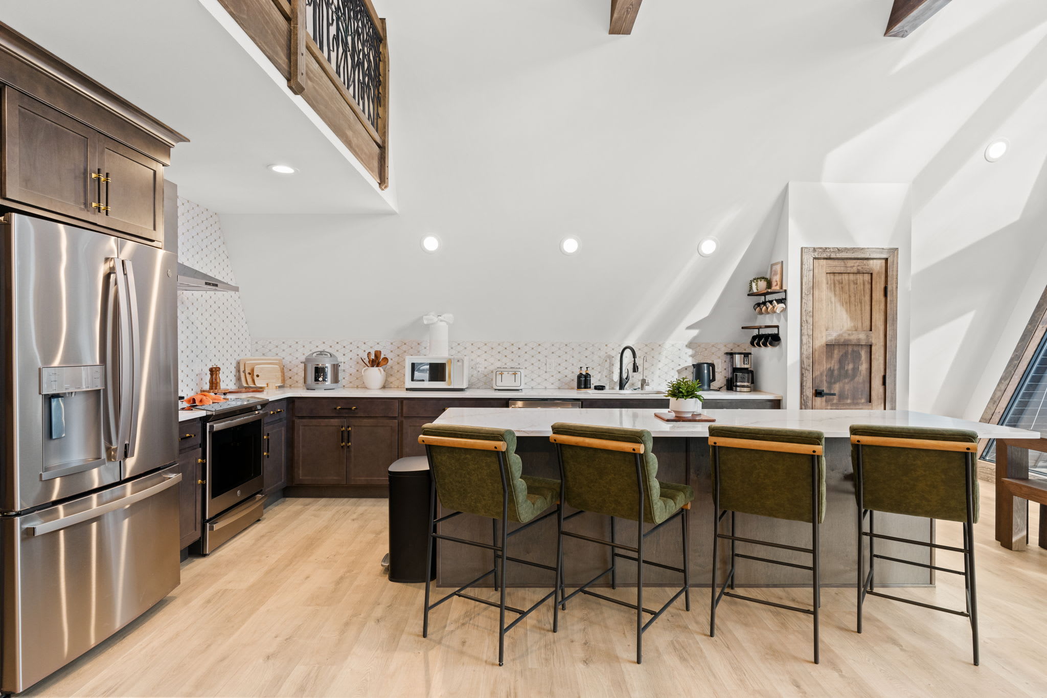 Dine beneath the soaring A-frame ceiling with staircase and loft above.