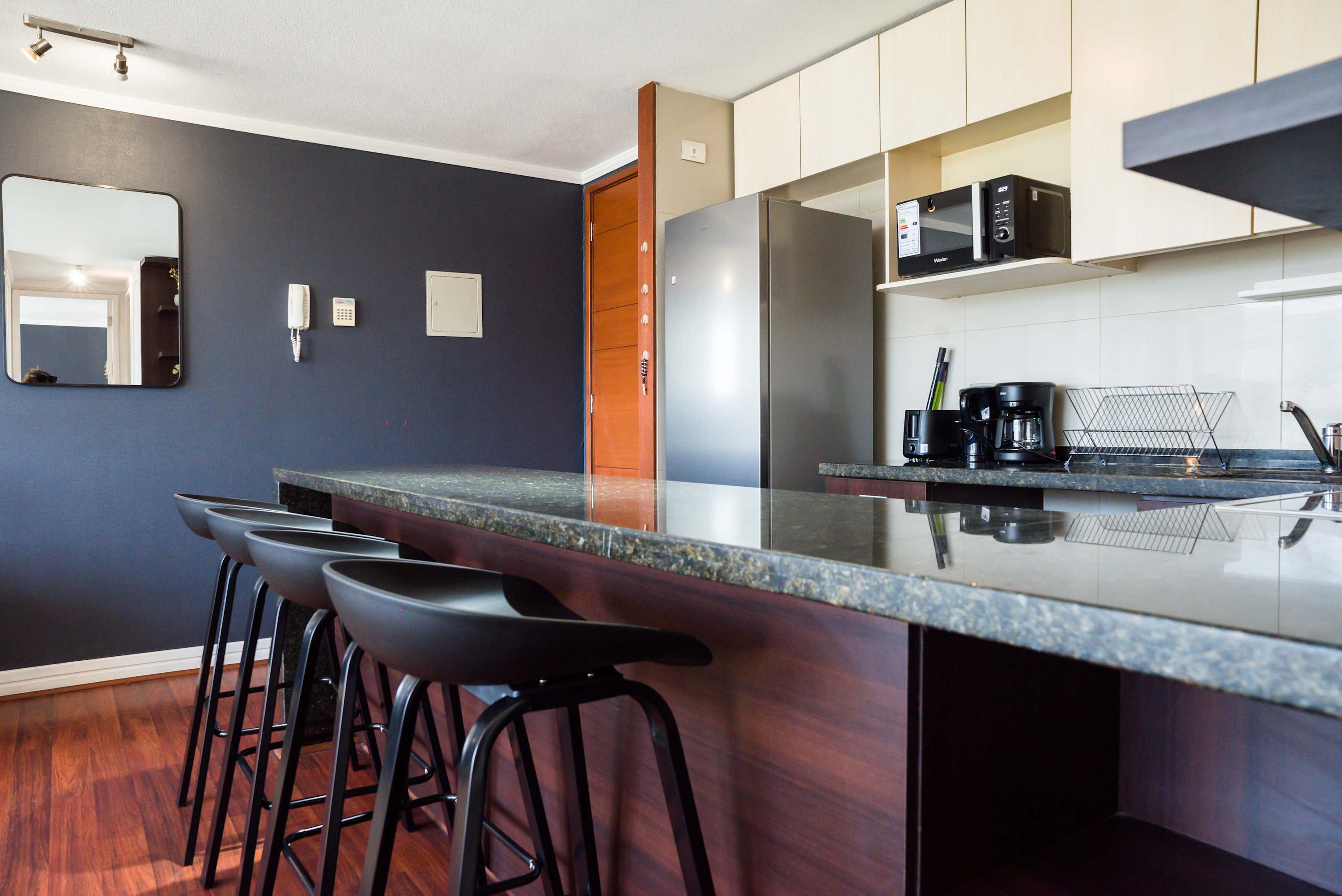 Sleek and modern kitchen with bar seating, perfect for enjoying a meal or coffee in style.