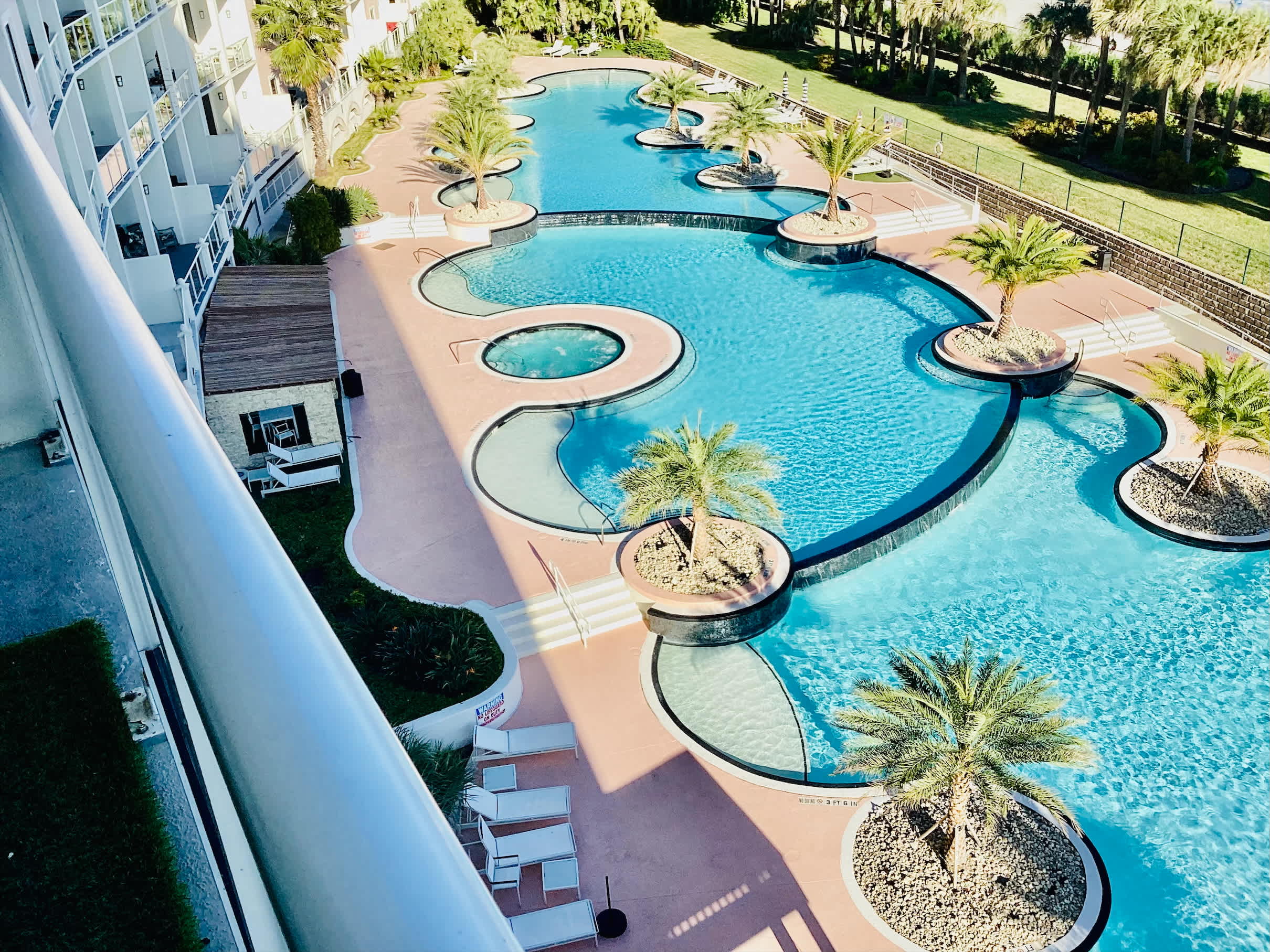 Resort pool area featuring hot tub and cozy lounge chairs