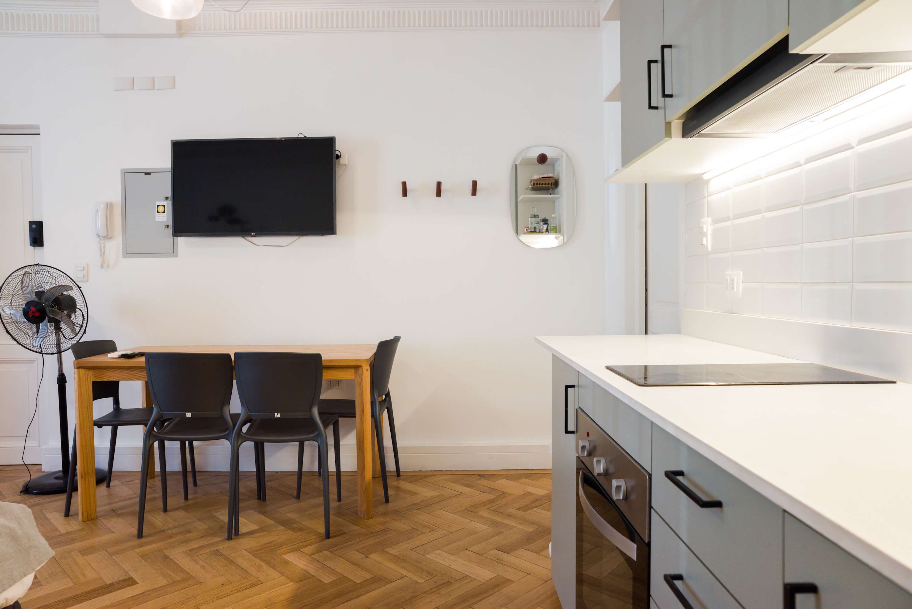 Modern dining area with sleek kitchen and cozy seating, perfect for intimate meals in a stylish setting.