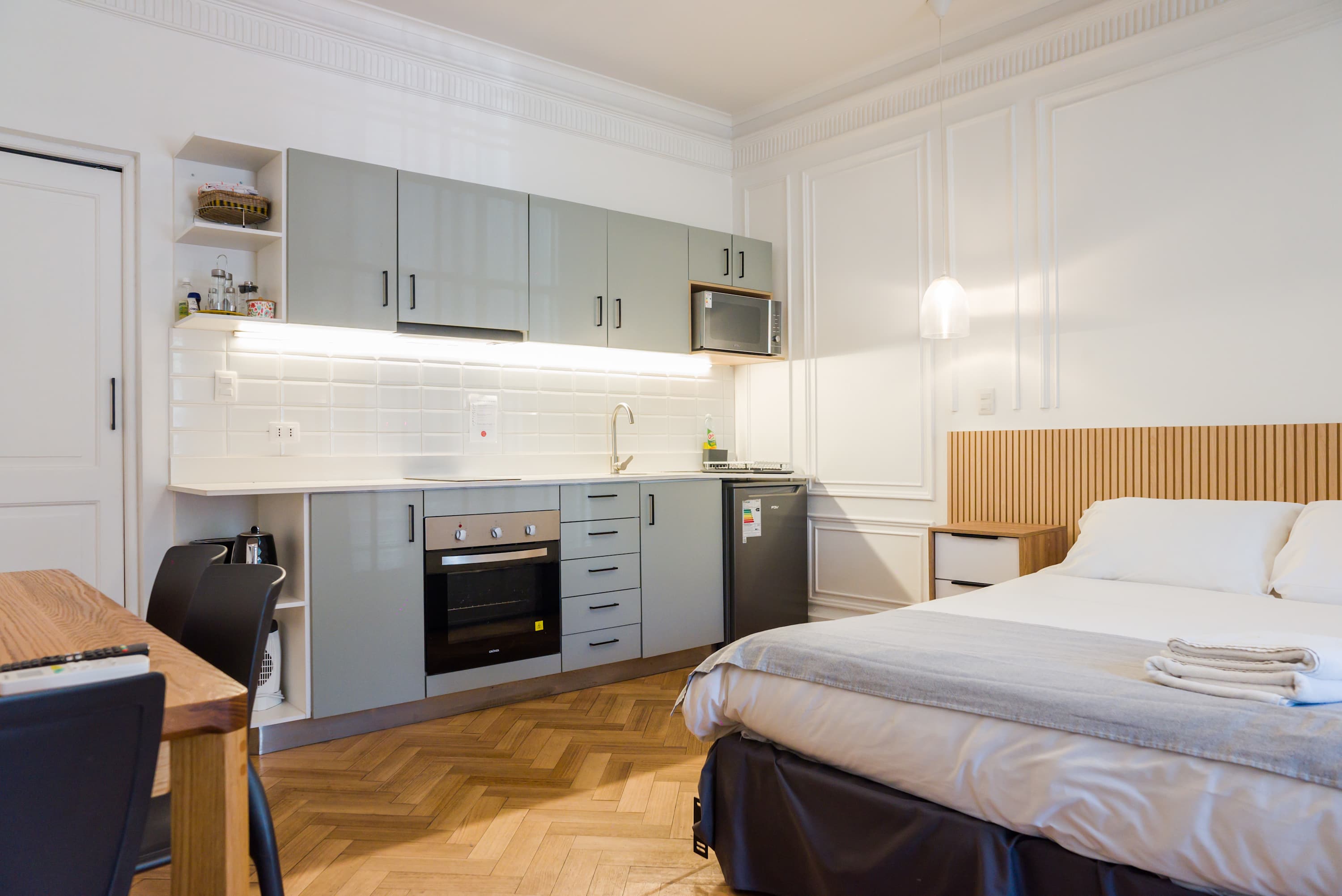 Chic studio apartment with modern kitchenette and cozy sleeping area, perfect for a comfortable stay in the heart of the city.