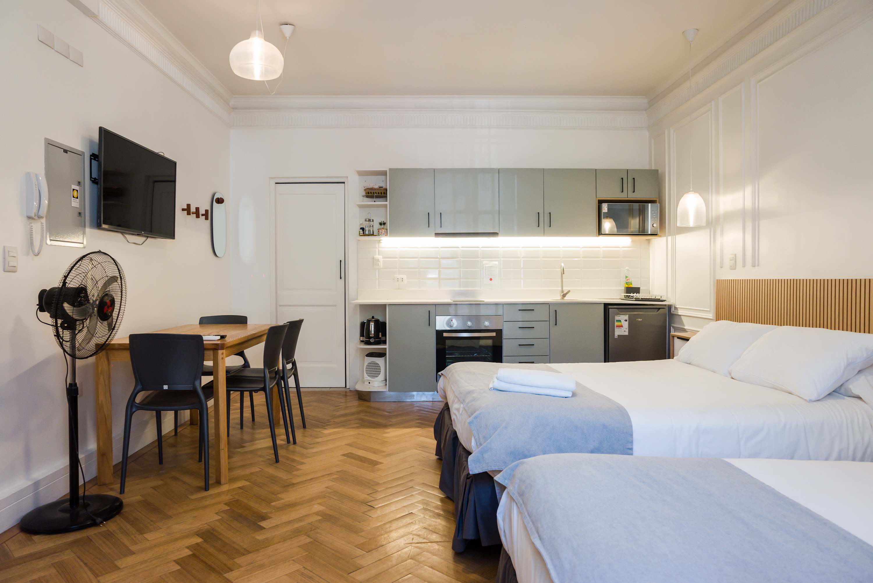 Relax in this chic studio with a modern kitchen, cozy beds, and elegant herringbone floors, perfect for a comfortable stay.