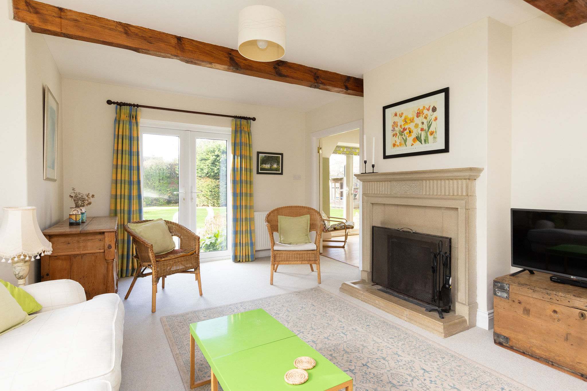 Light and airy lounge with plenty of seating, tv and open fire