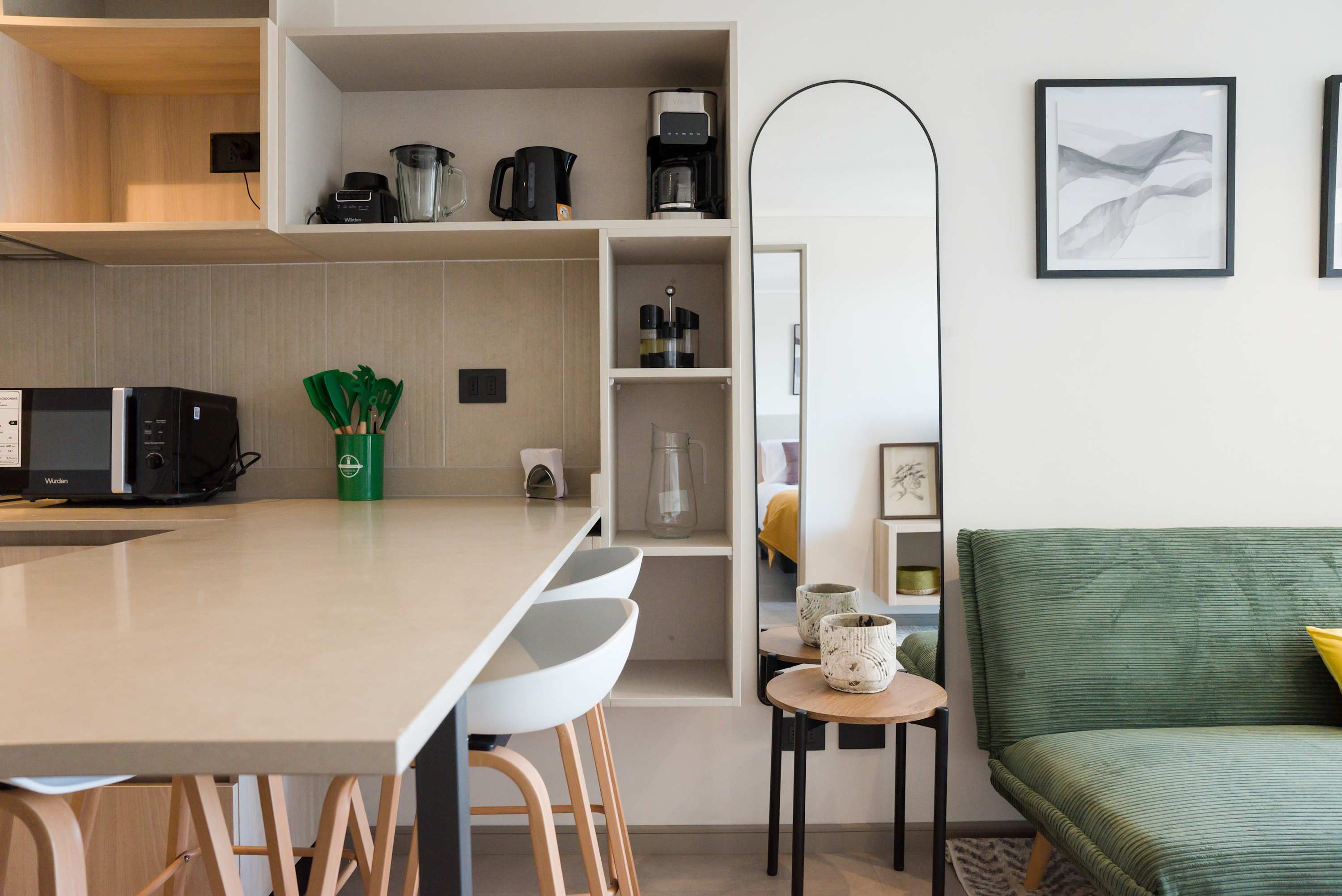 Modern kitchen with sleek appliances and cozy seating, ideal for unwinding after a day in the city.