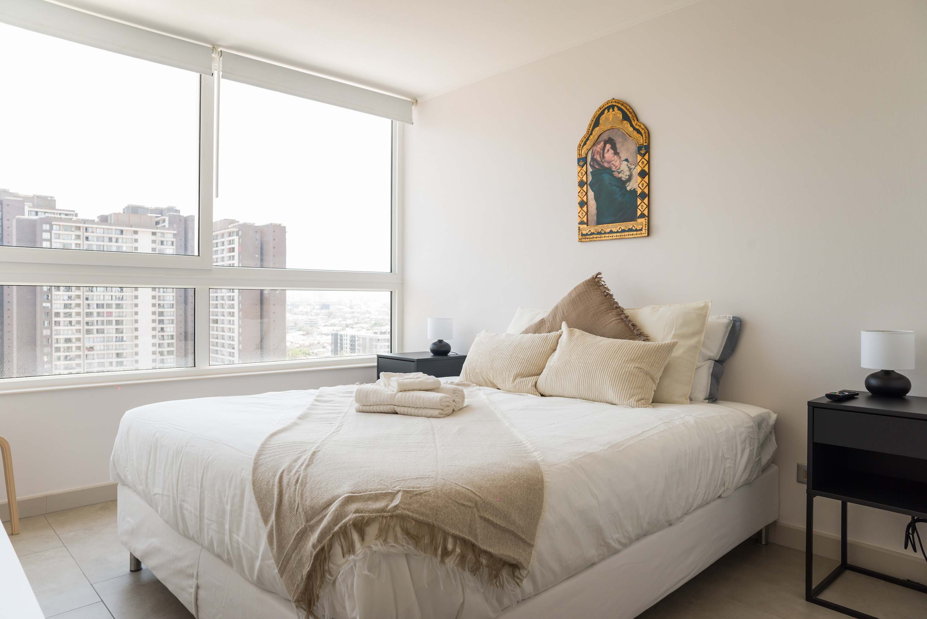 Relax in this cozy bedroom with stunning city views and elegant decor, perfect for unwinding after a day of exploring.