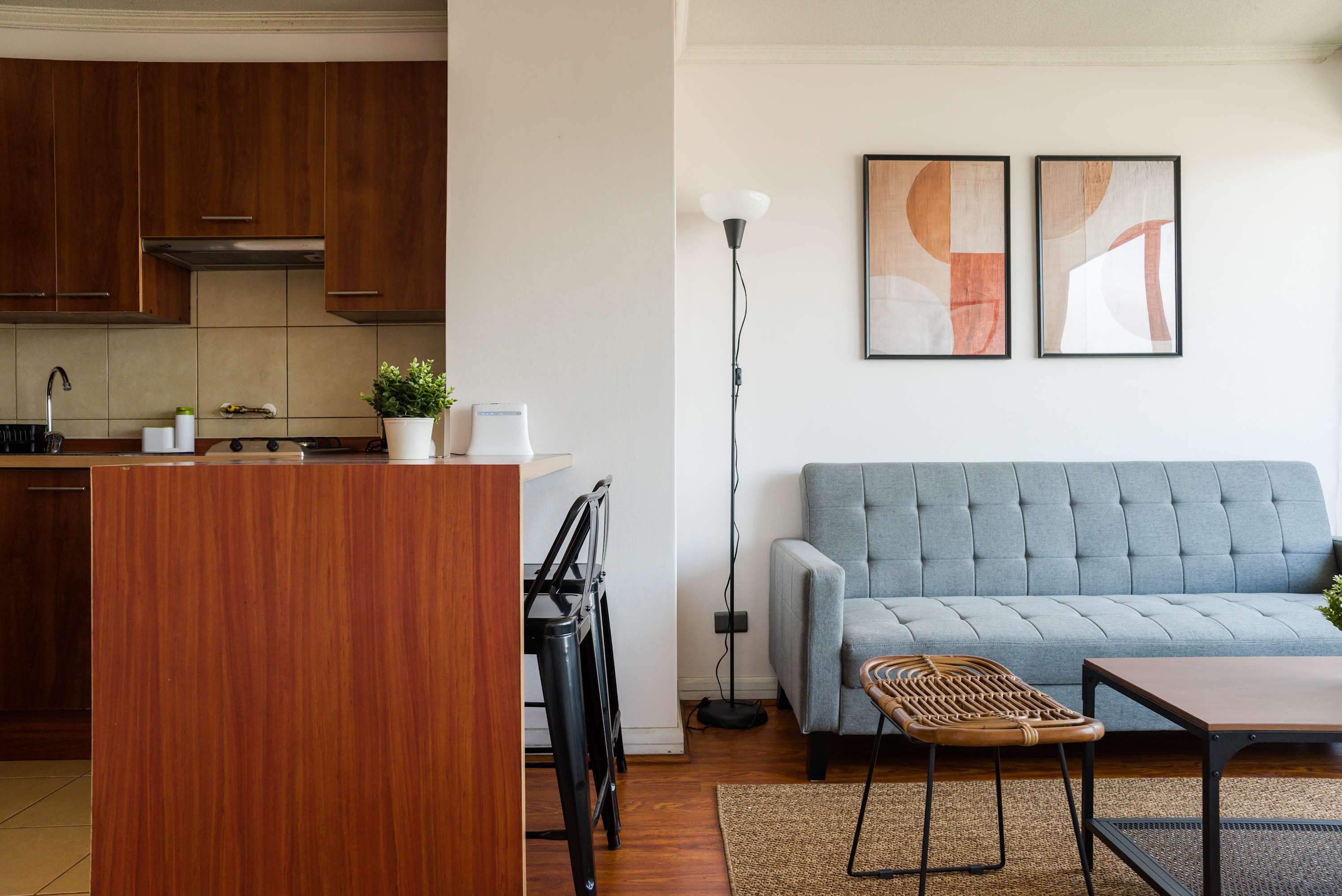 Stylish living area with a cozy sofa and functional kitchen, perfect for relaxation and comfort.