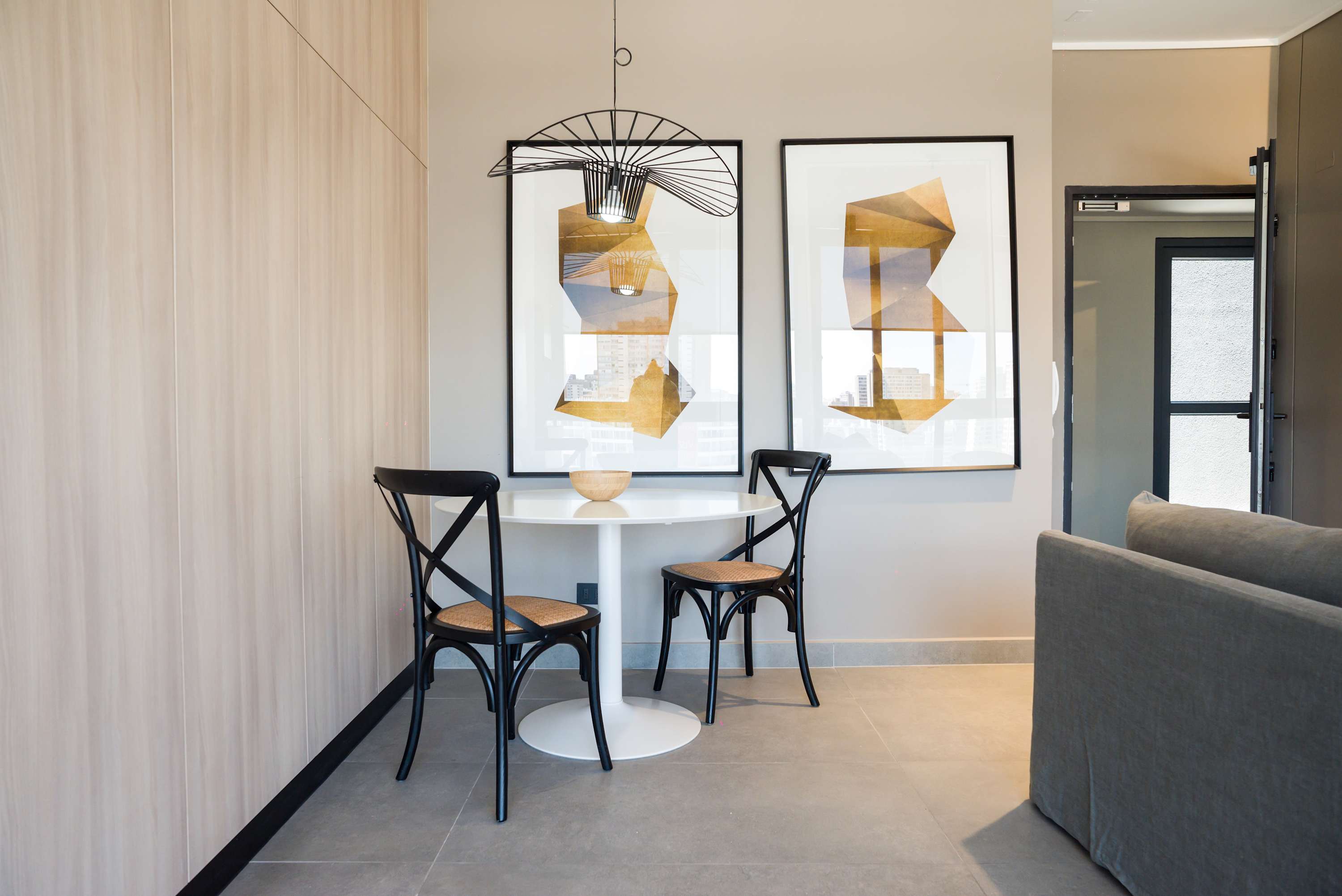 Cozy dining nook with modern art and natural light, perfect for intimate meals.