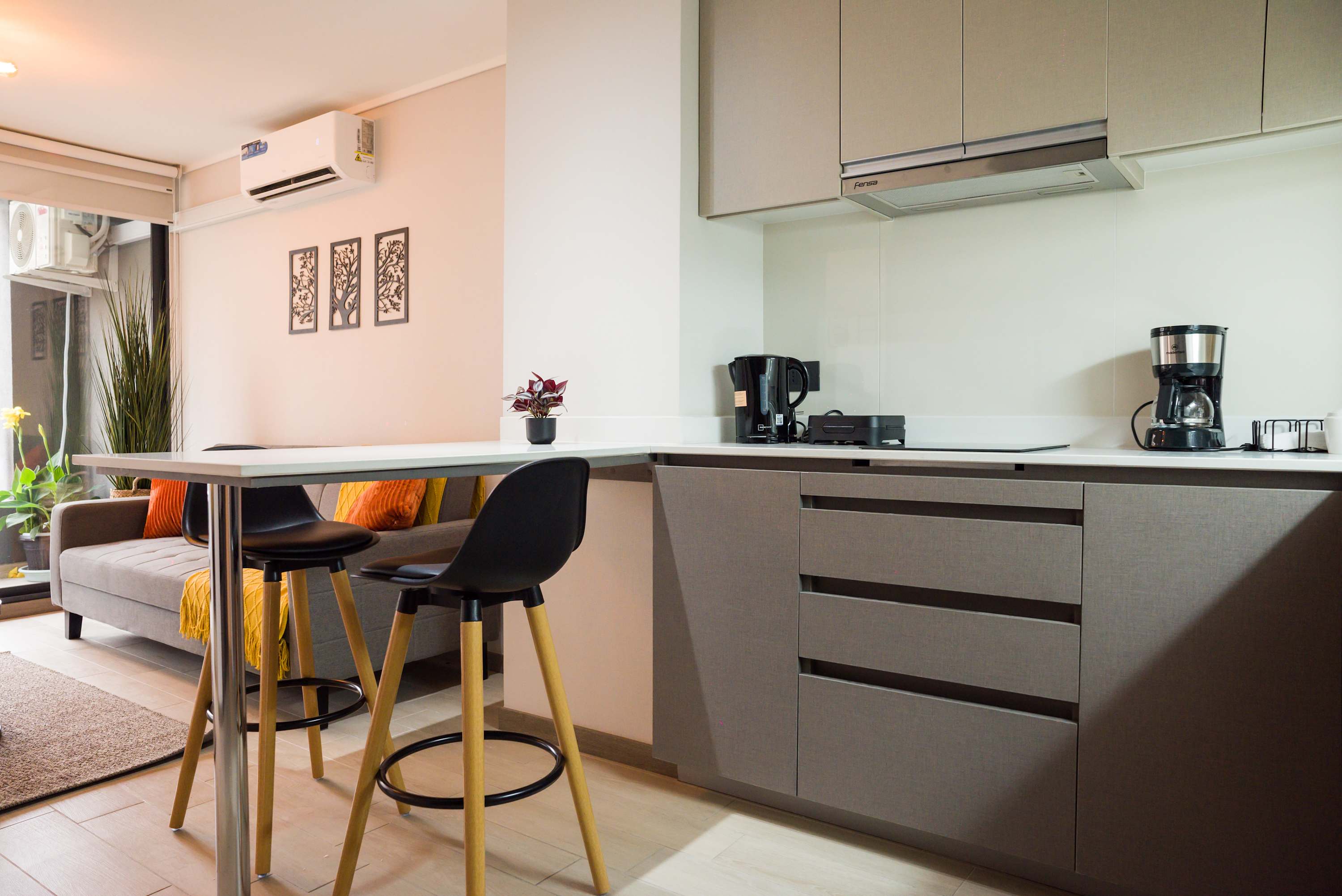 Modern kitchen and cozy dining area with stylish decor and natural light, perfect for a comfortable stay.