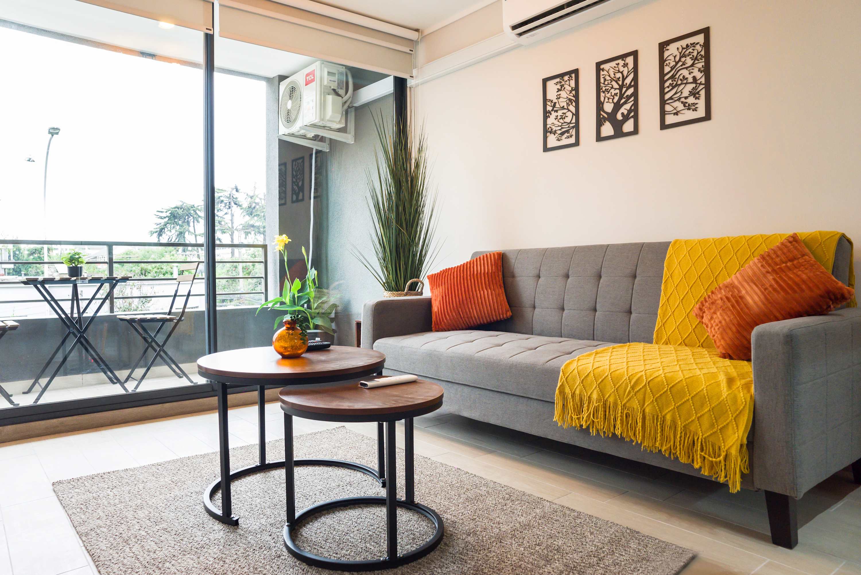 Bright and cozy living area with vibrant decor and a charming balcony view, perfect for unwinding.