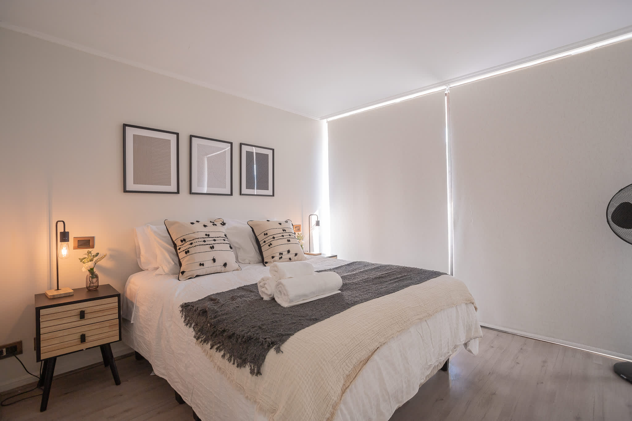 Unwind in this stylish bedroom with cozy bedding and soft lighting, ideal for a peaceful retreat.