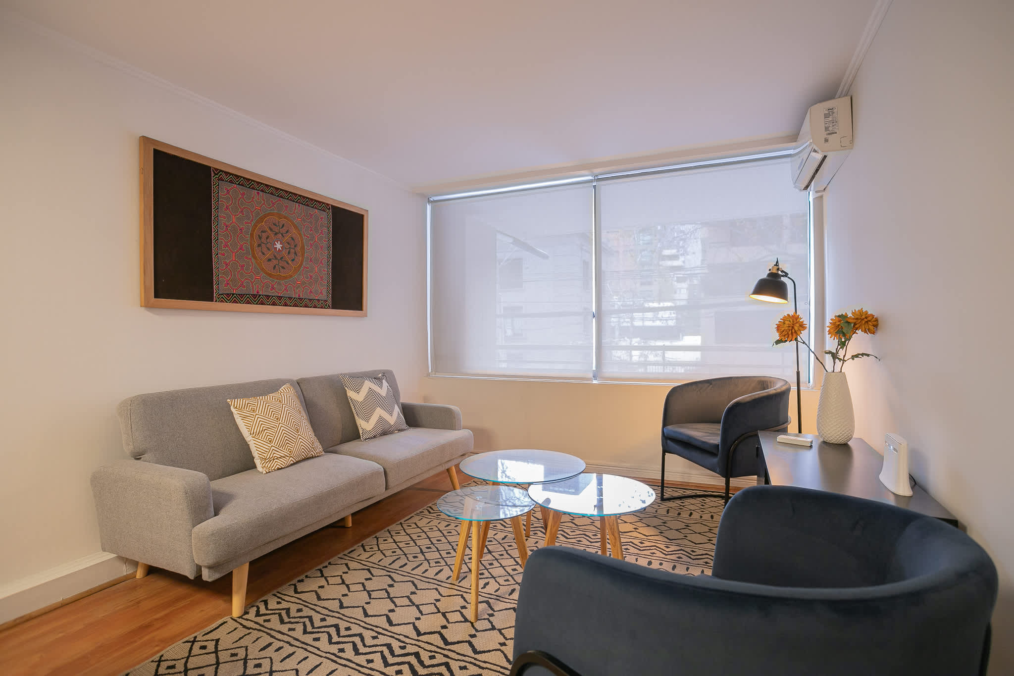 Enjoy the cozy ambiance of this modern living room with chic decor and ample natural light.