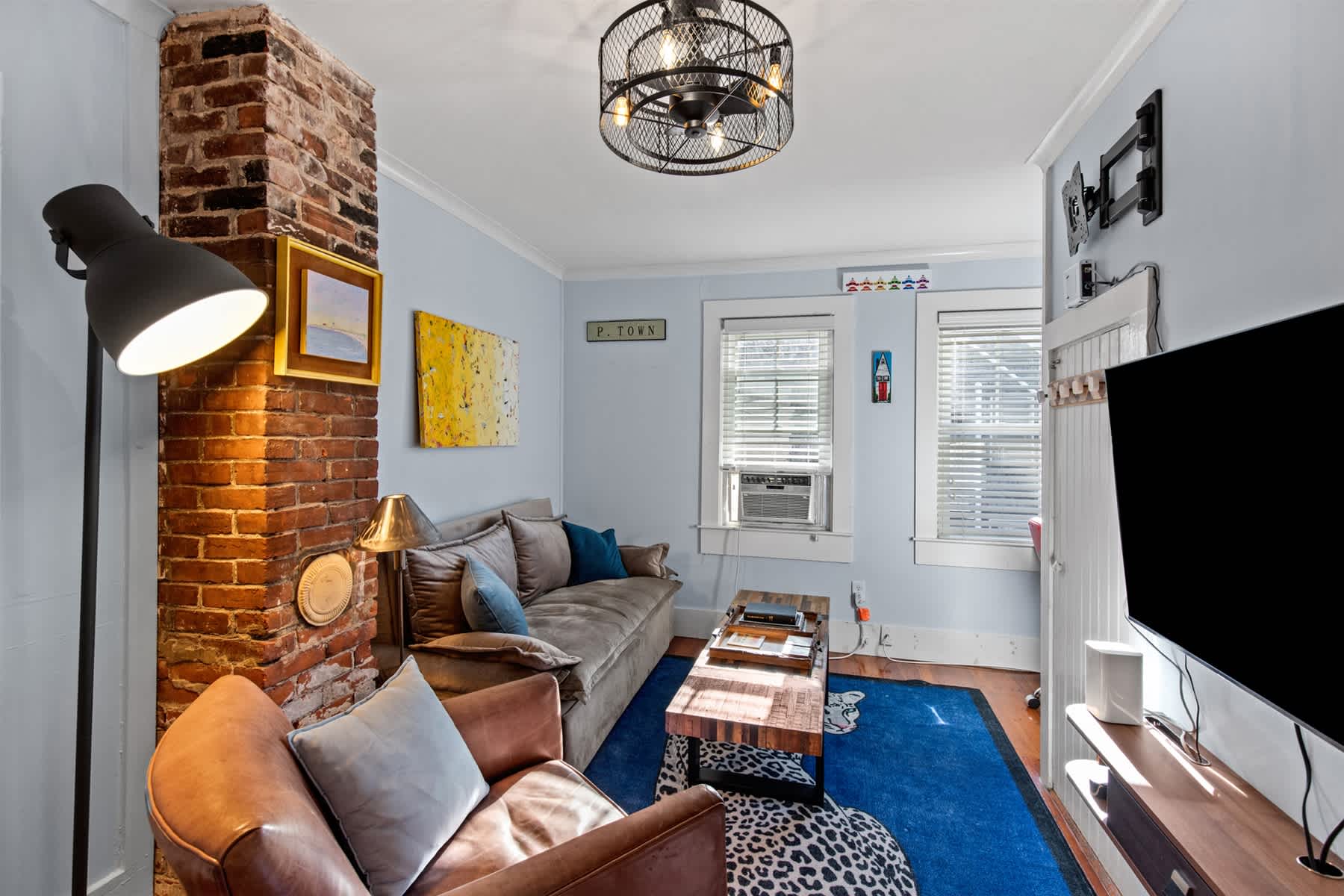 Bright and inviting living room featuring a cozy sofa, armchair, and smart TV, perfect for relaxing after a day exploring Cape Cod.