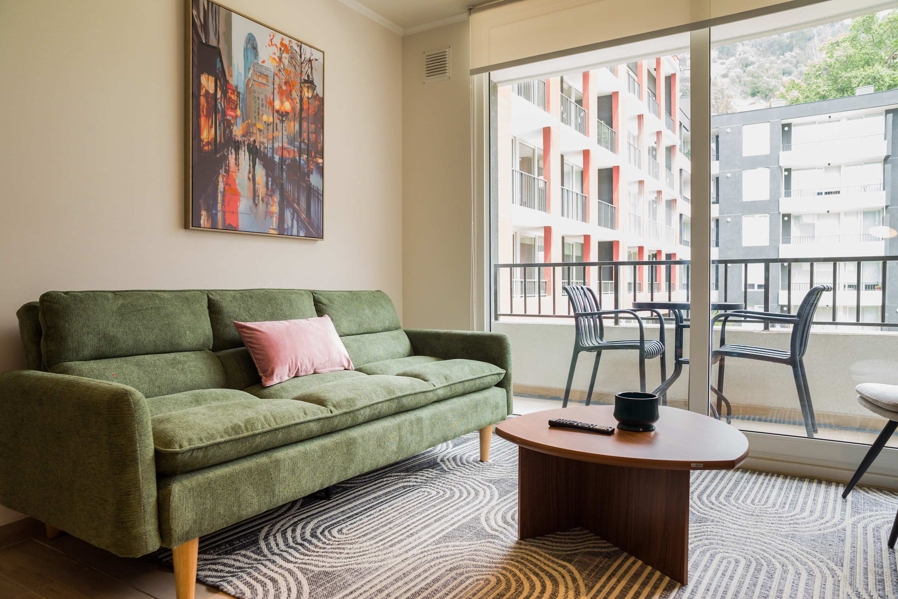 Enjoy a cozy evening in this stylish living room with a vibrant balcony view, perfect for relaxation.