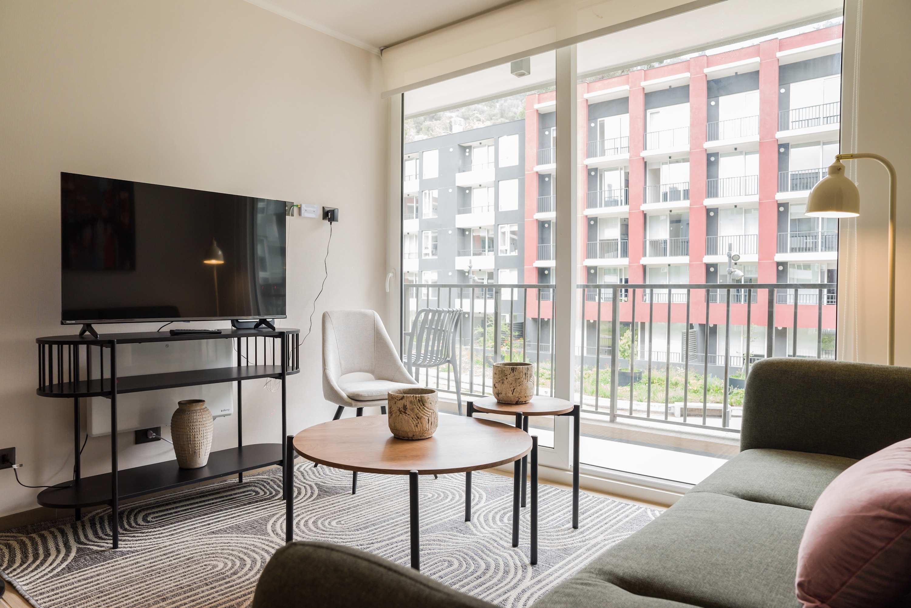 Modern living room with large windows and stylish decor, offering a cozy space to relax and enjoy the view.