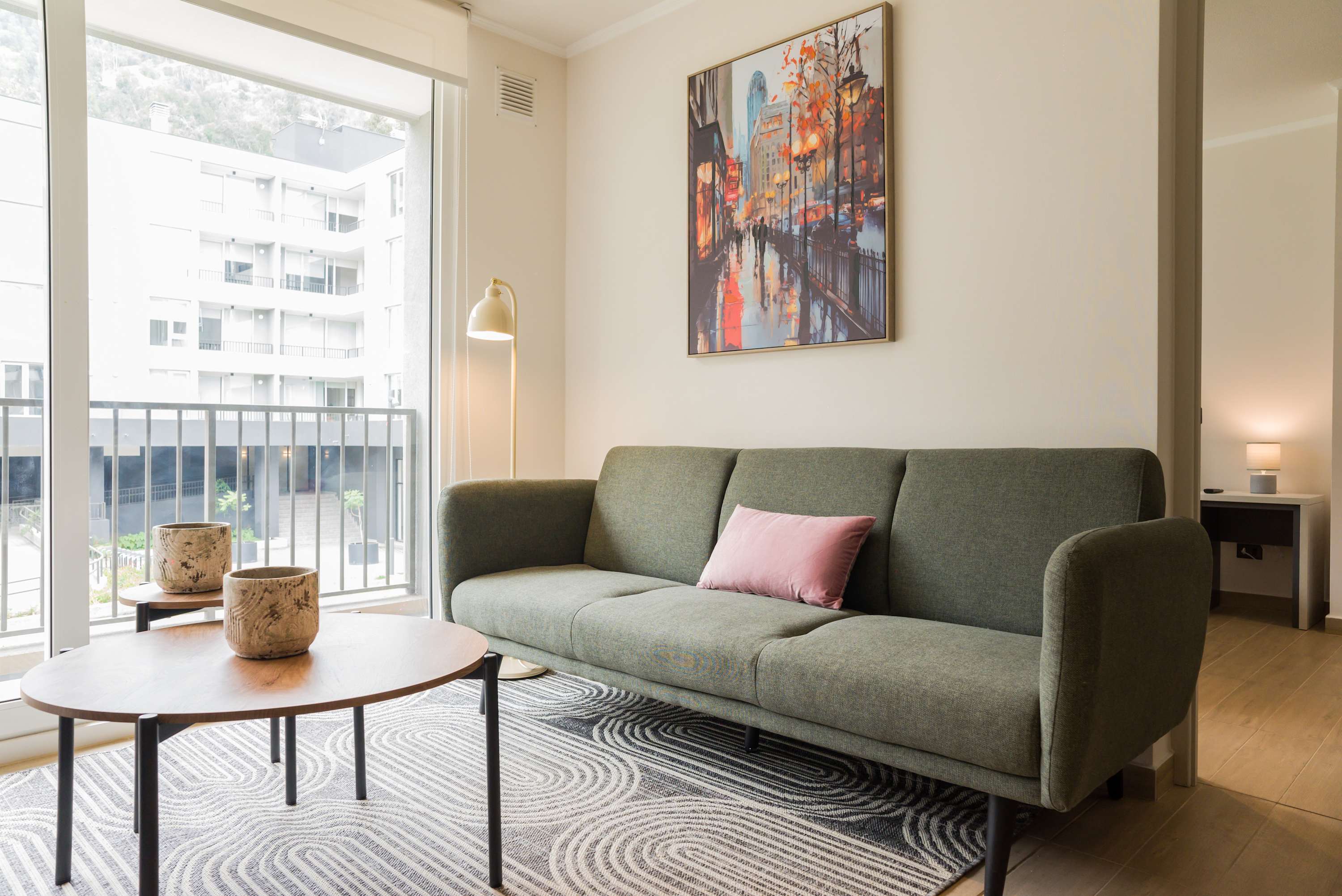 Relax in this stylish living room with a comfy sofa and vibrant city views, perfect for unwinding after a day of exploring.