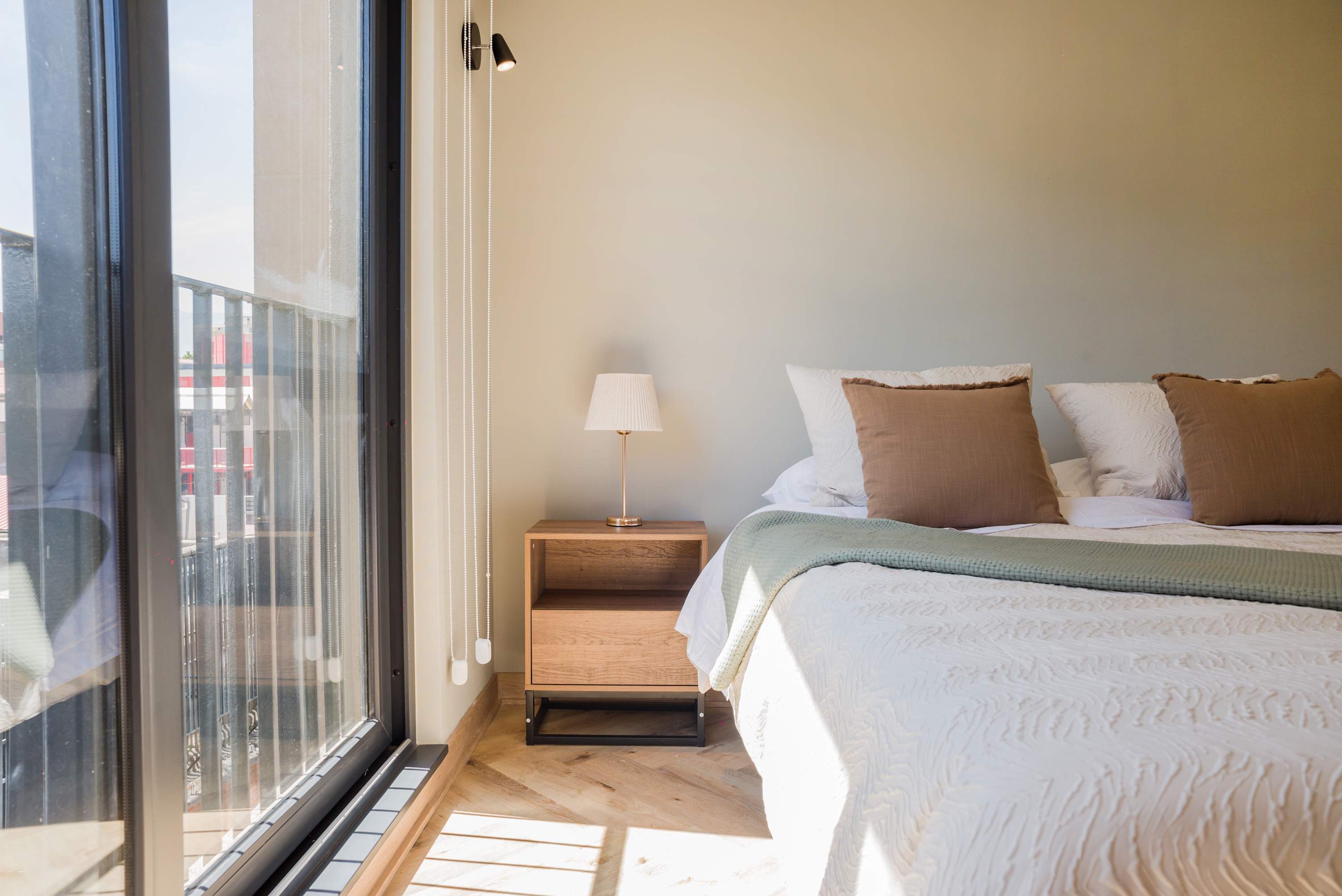 Bright and cozy bedroom with large windows offering plenty of natural light and a comfortable bed for a restful stay.