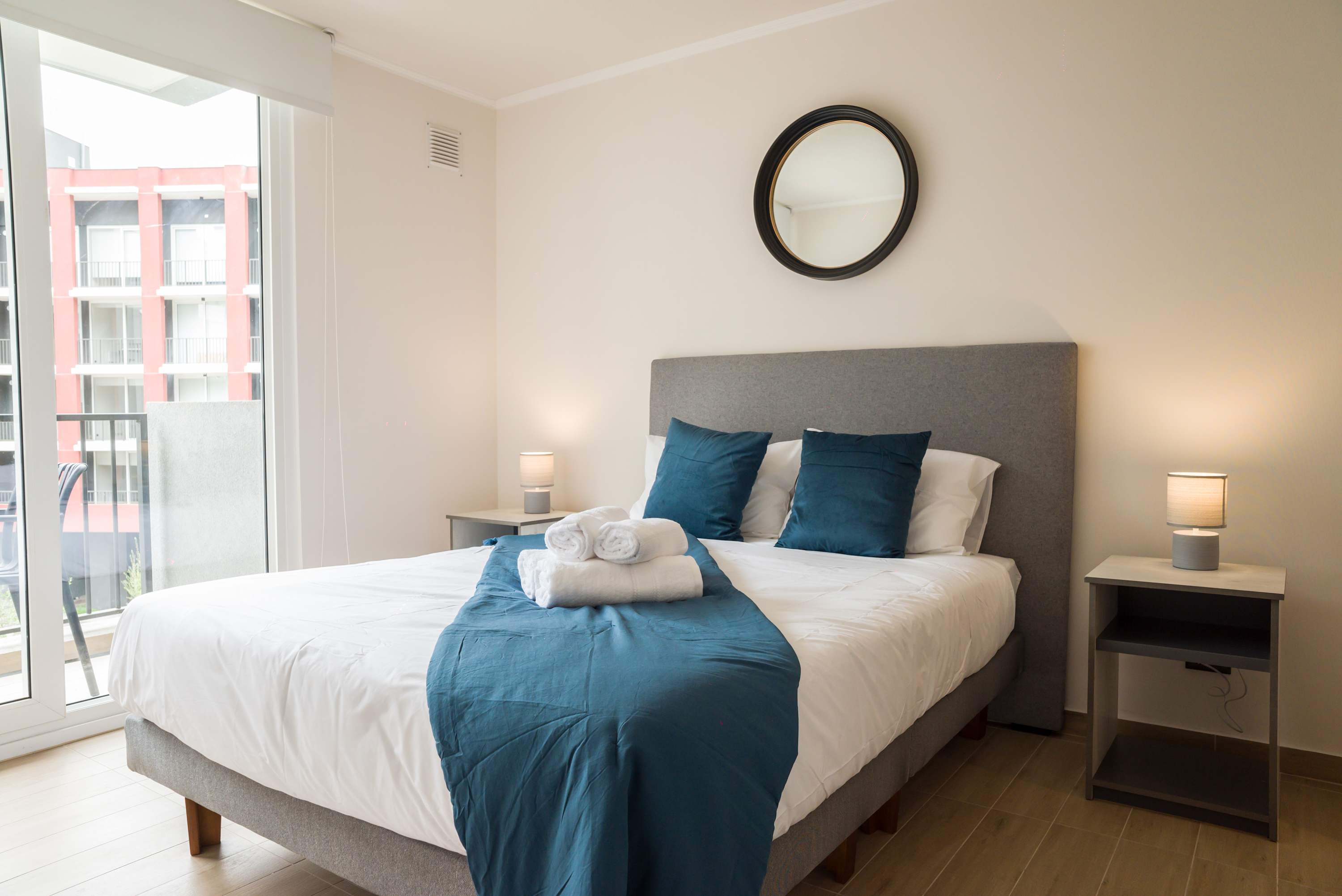 Relax in this cozy bedroom with a comfy bed and natural light from the balcony view.