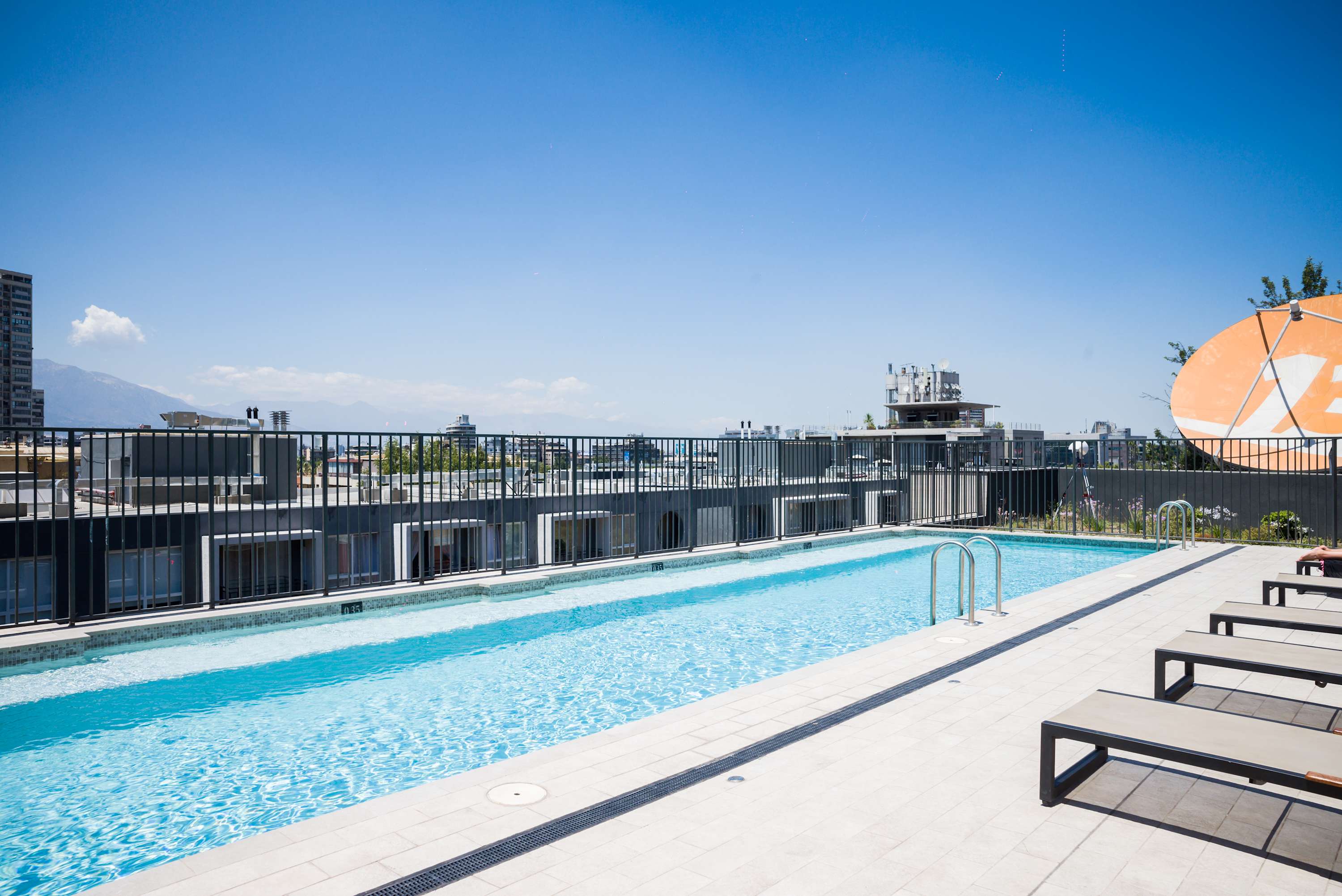 Enjoy a swim in the rooftop pool with stunning city and mountain views. Perfect for relaxation and sunbathing.