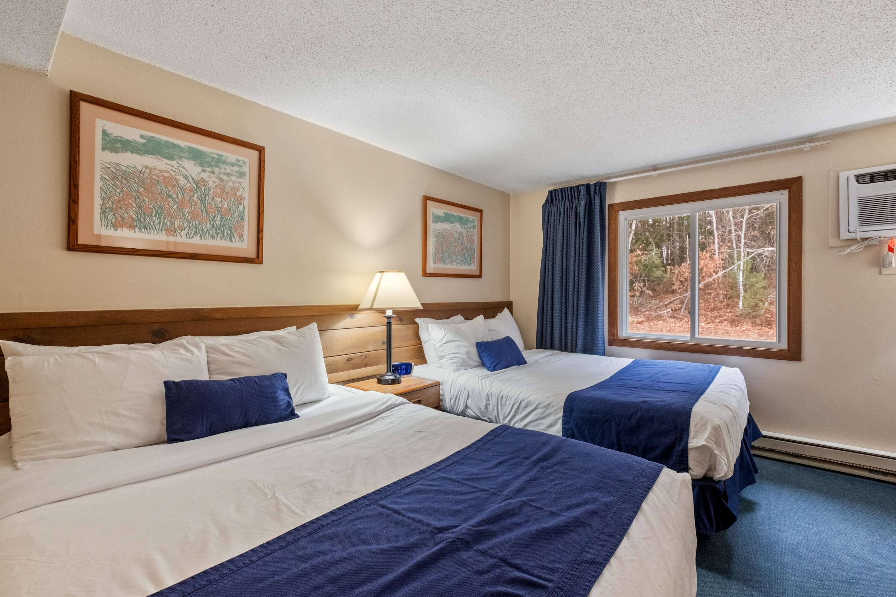 A pair of plush queen beds & a smart TV await in the bedroom retreat ​