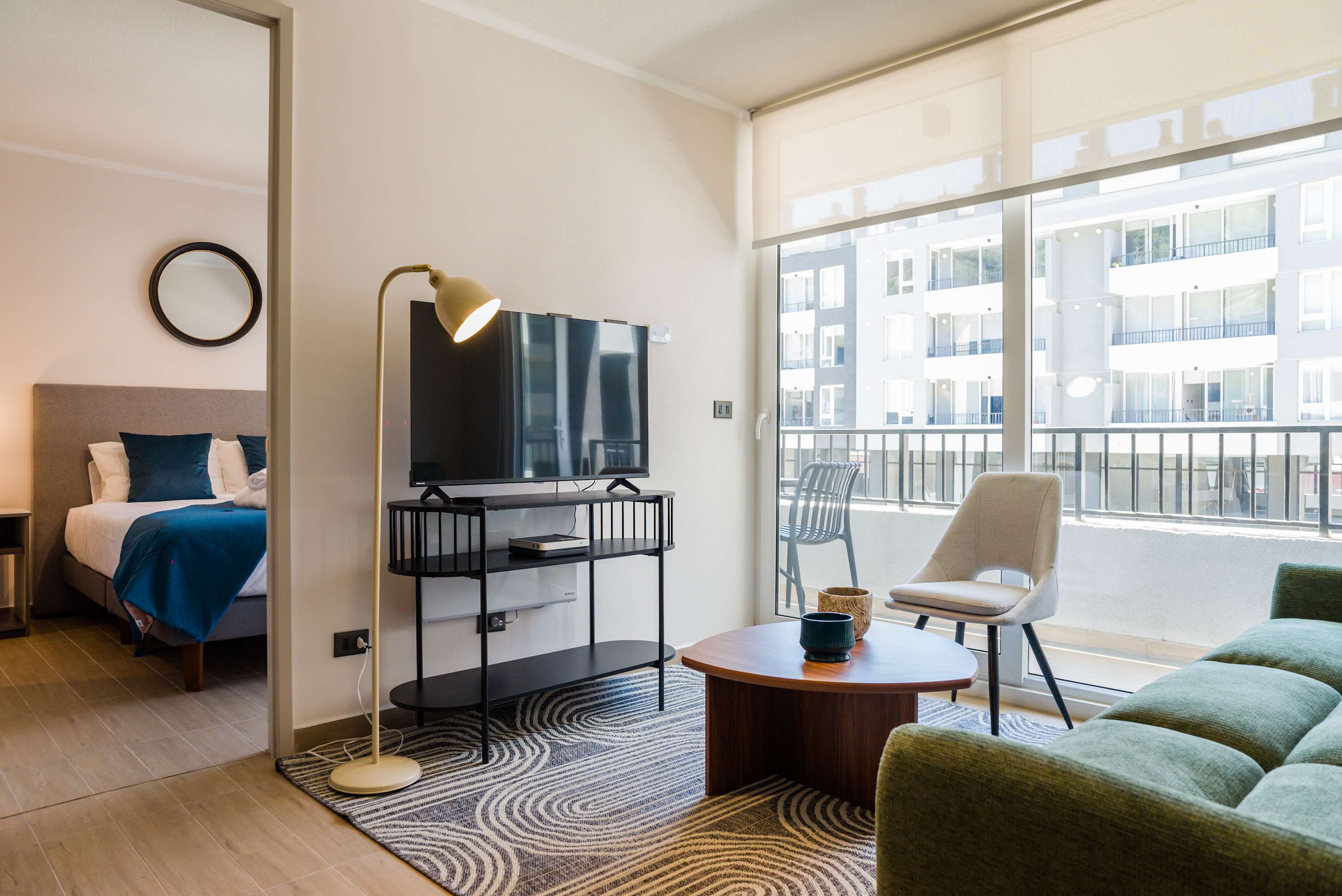 Bright and cozy living area with modern furnishings and a balcony view, perfect for relaxation.