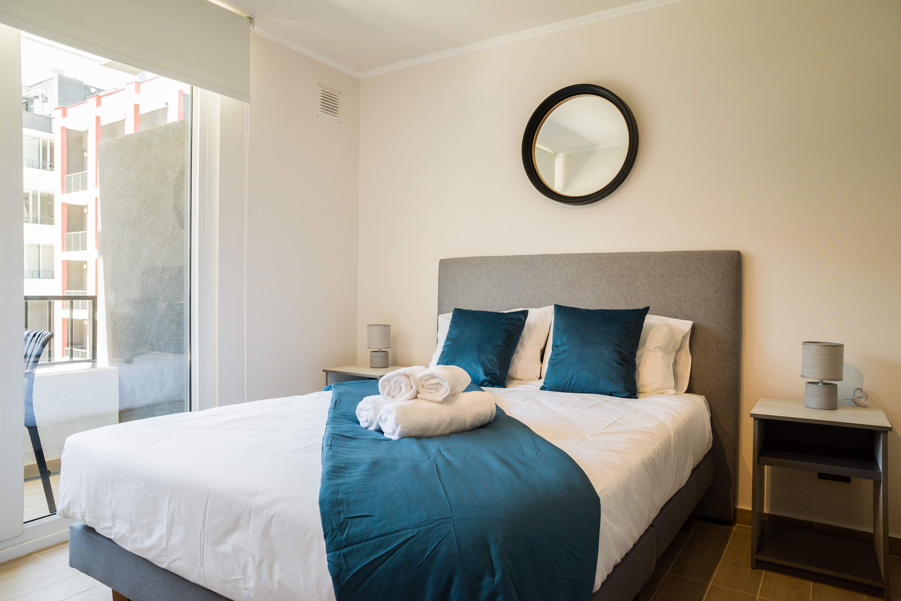 Relax in this cozy bedroom with plush bedding and a private balcony view, perfect for unwinding after a day of exploring.