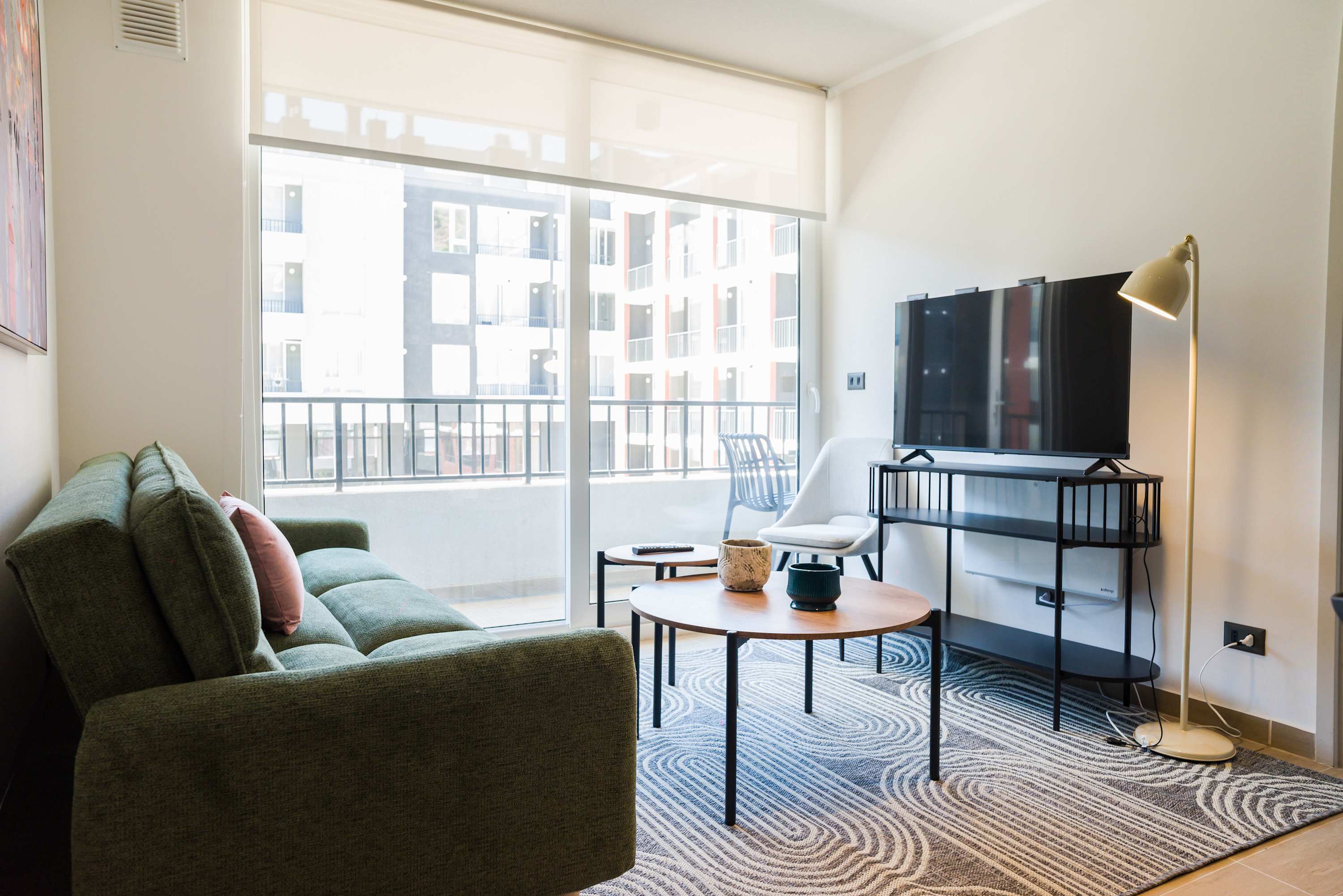 Bright and modern living room with balcony access, perfect for relaxation and entertainment.