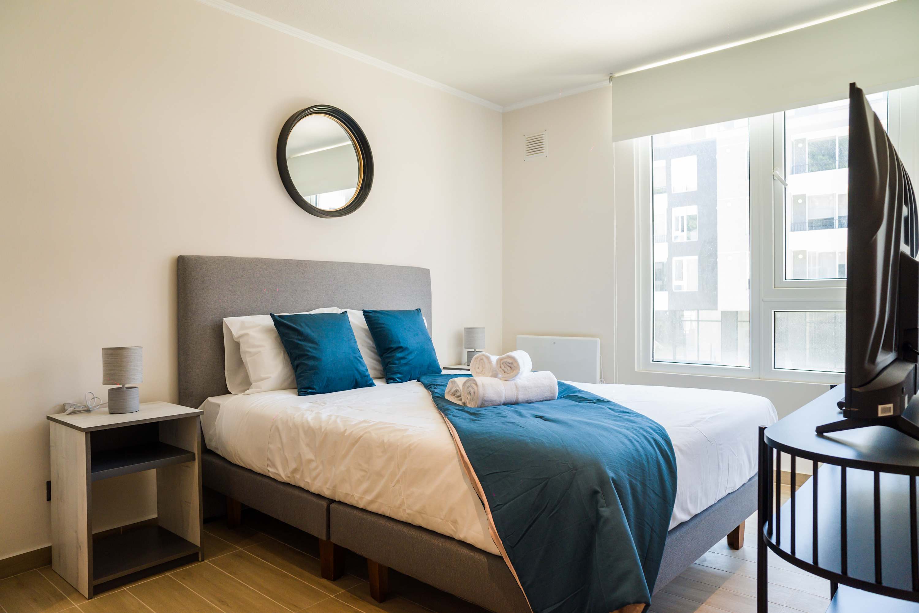 Relax in this cozy bedroom with natural light and stylish decor, perfect for unwinding after a day of exploring.