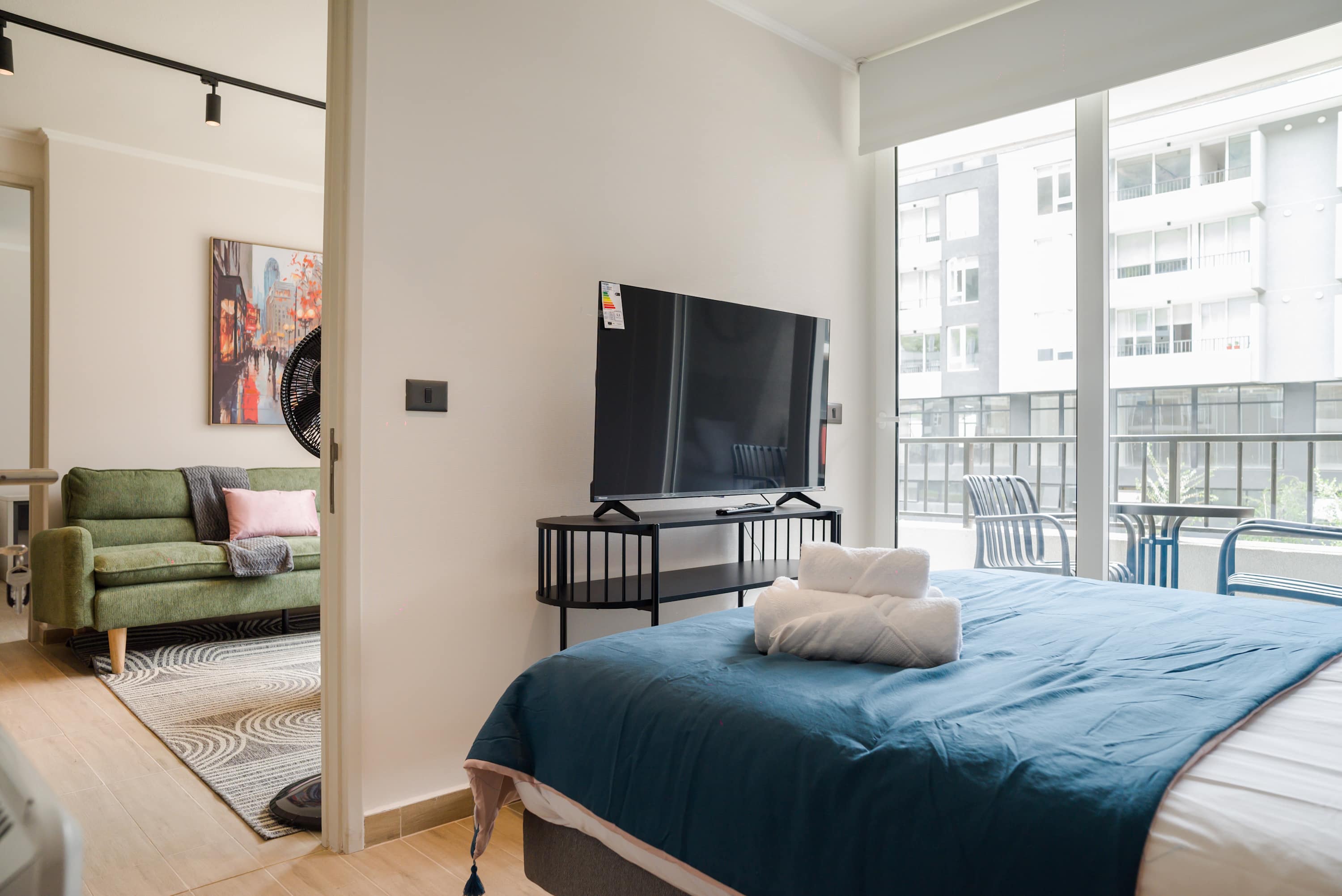 Bright and cozy bedroom with a TV and access to a balcony for a refreshing view.