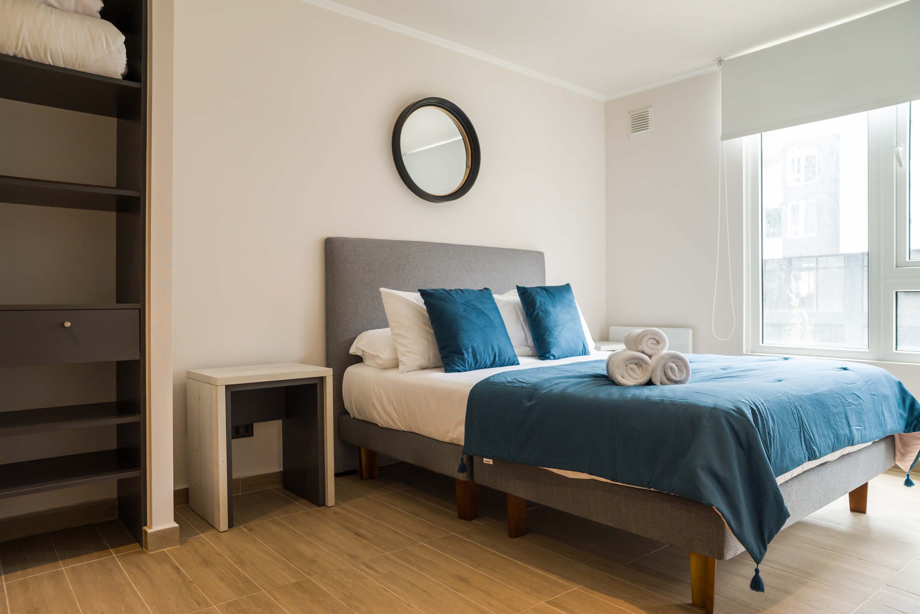 Relax in this cozy bedroom with plush bedding and ample natural light, perfect for a restful stay.