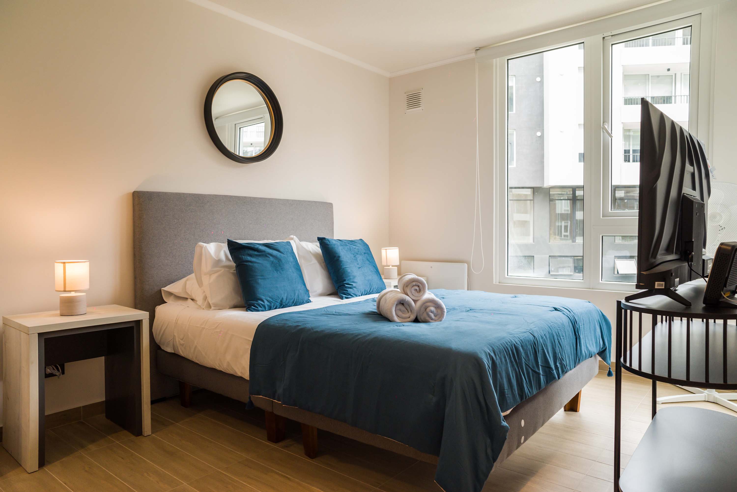 Relax in this cozy bedroom with natural light and modern decor, perfect for a restful stay.