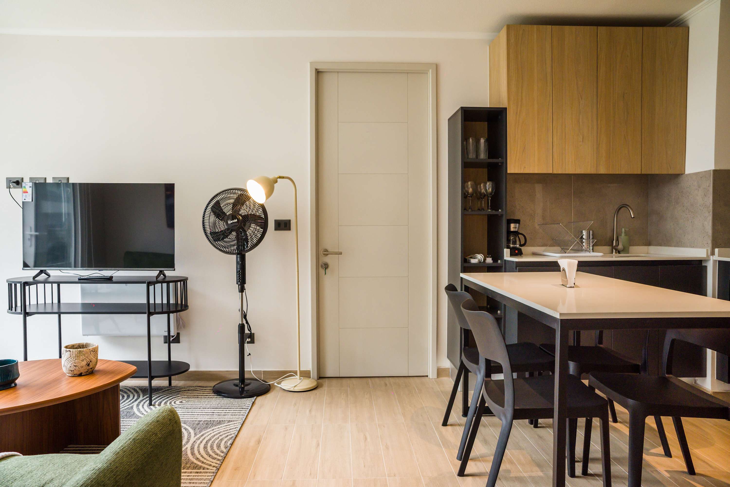 Cozy living area with modern amenities and a sleek kitchenette, perfect for relaxation and dining.