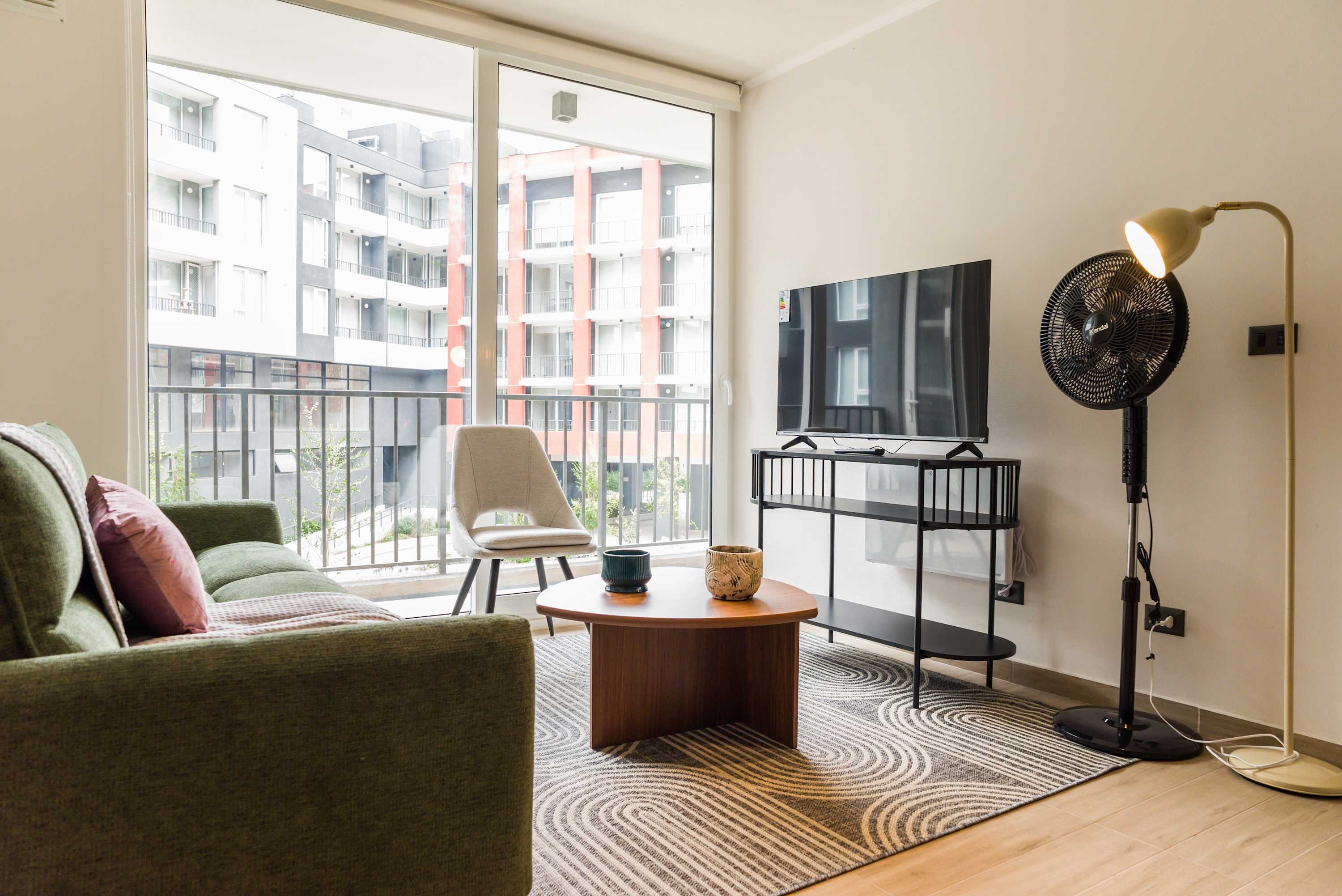 Bright and modern living room with a cozy sofa and large window overlooking the cityscape.