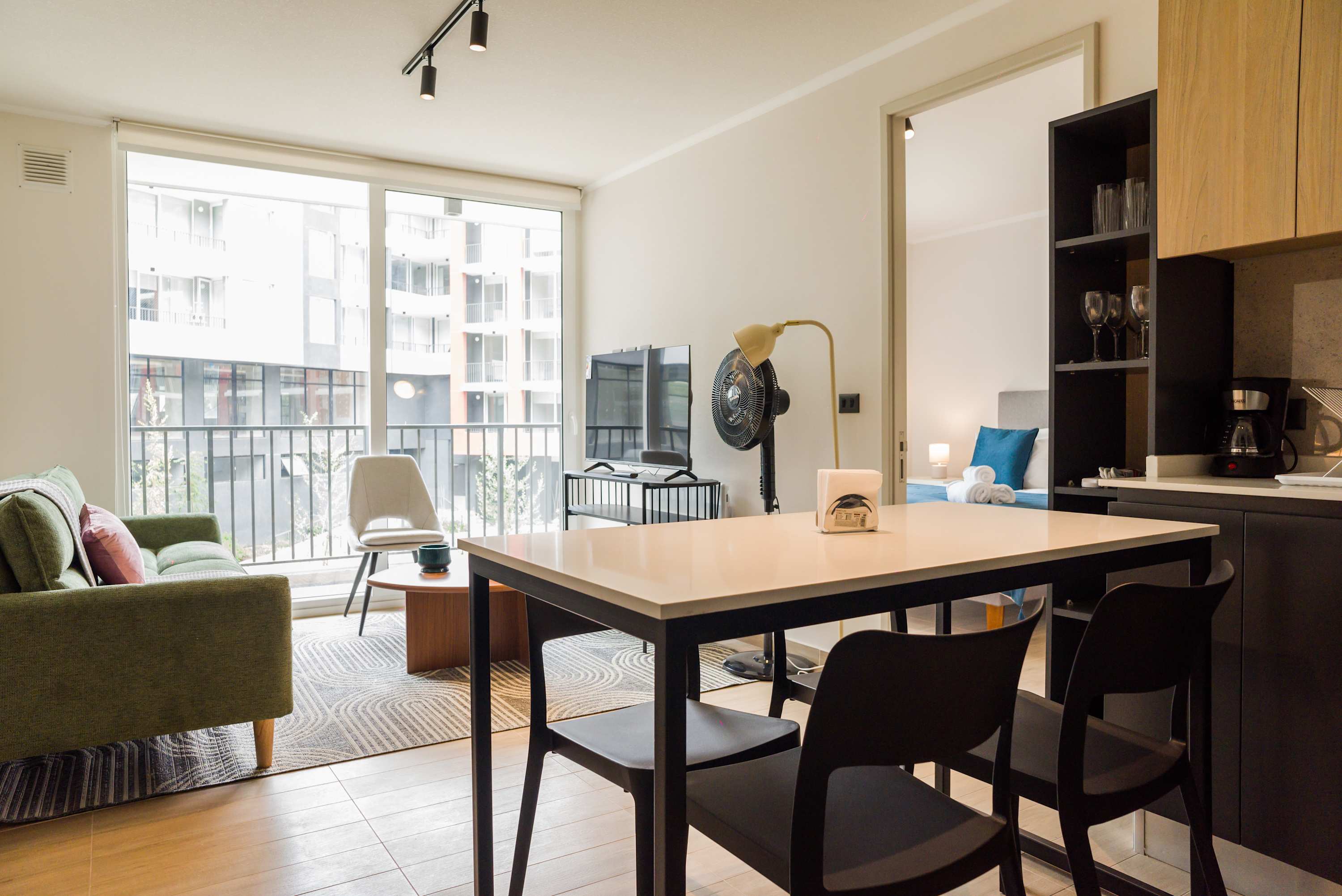 Bright and modern living space with large windows and cozy seating, perfect for relaxation.