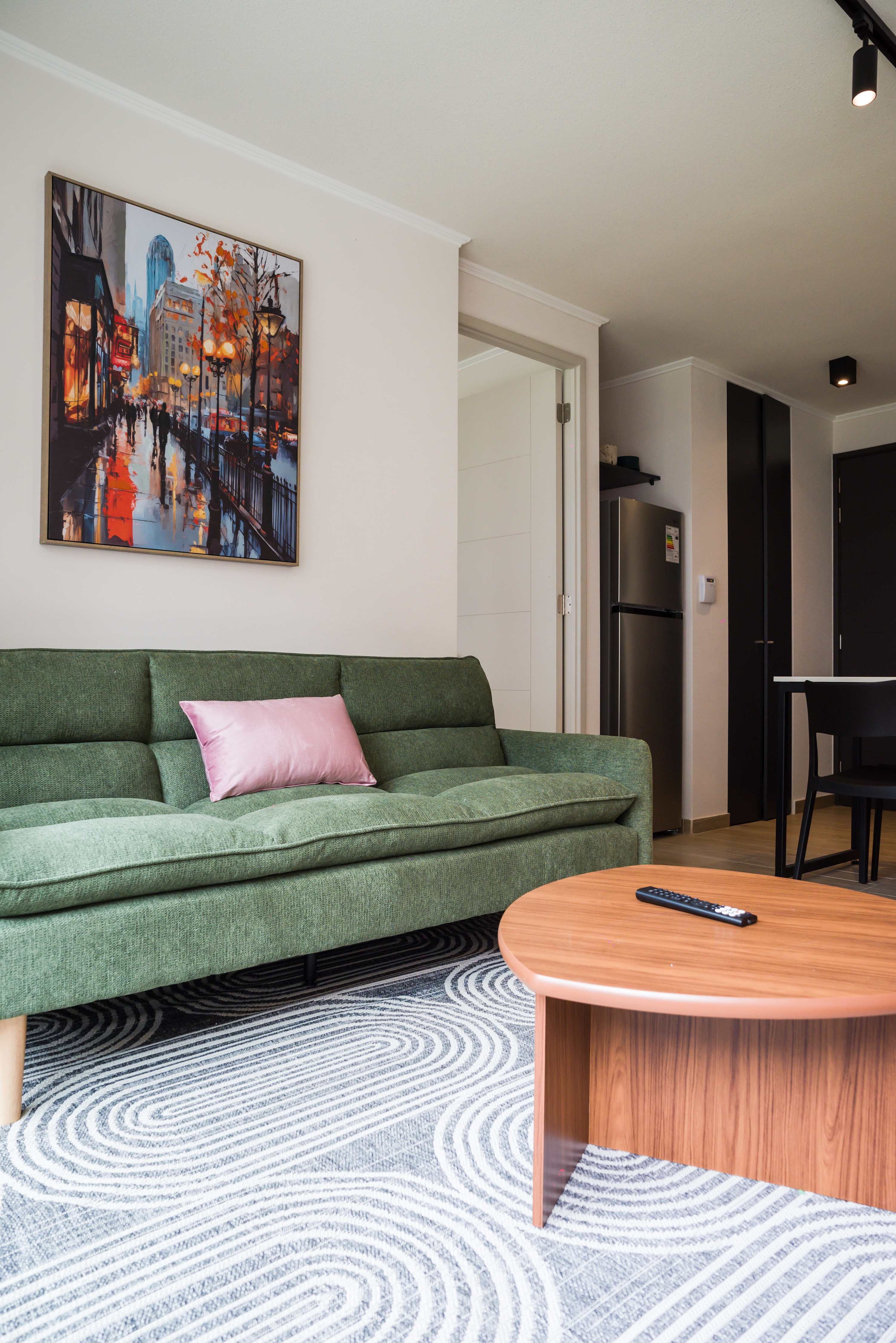 Relax in this stylish living room with a comfy sofa and vibrant artwork, perfect for unwinding after a day of exploring.