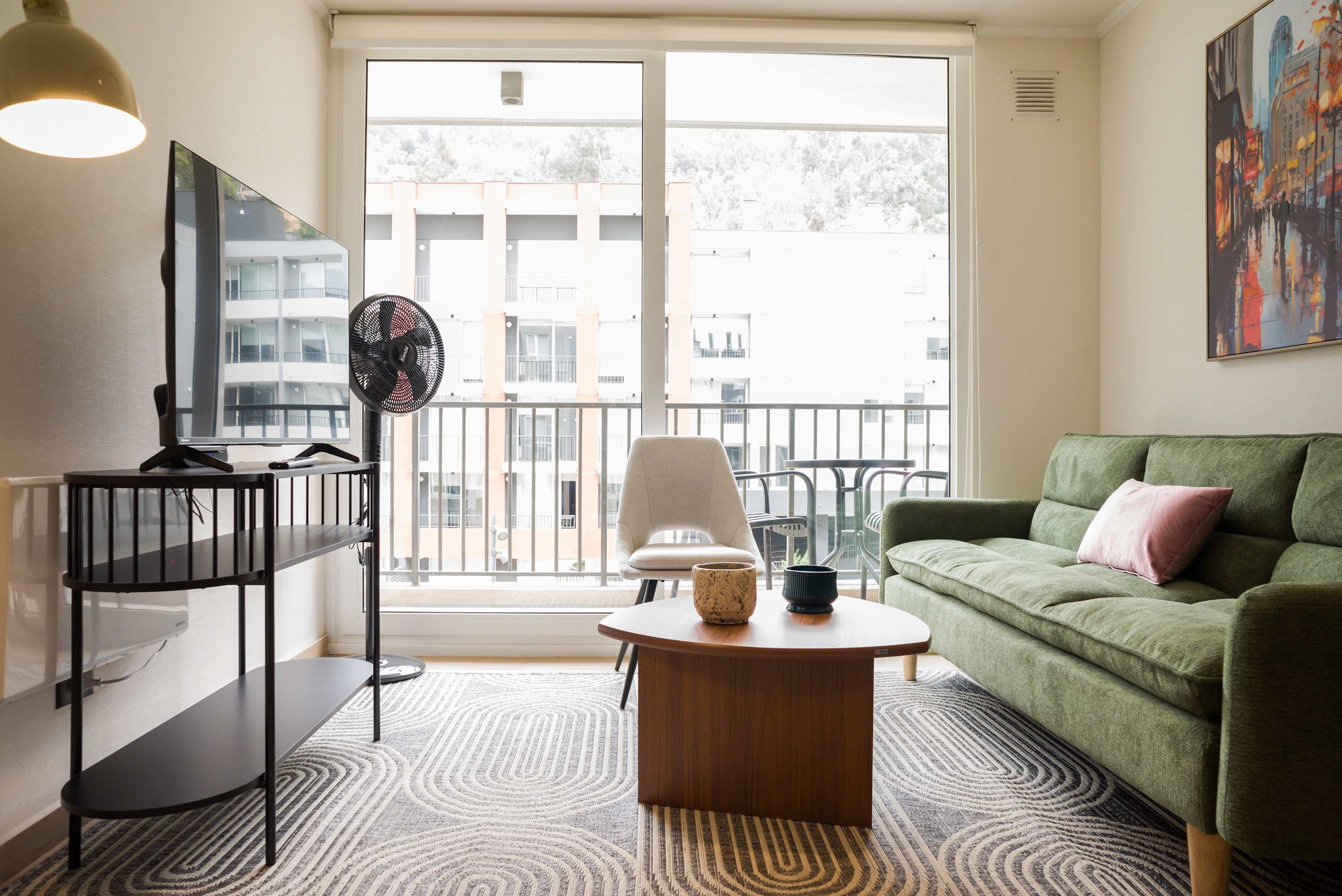 Relax in this cozy living room with a comfy green sofa and enjoy the view from the large windows.