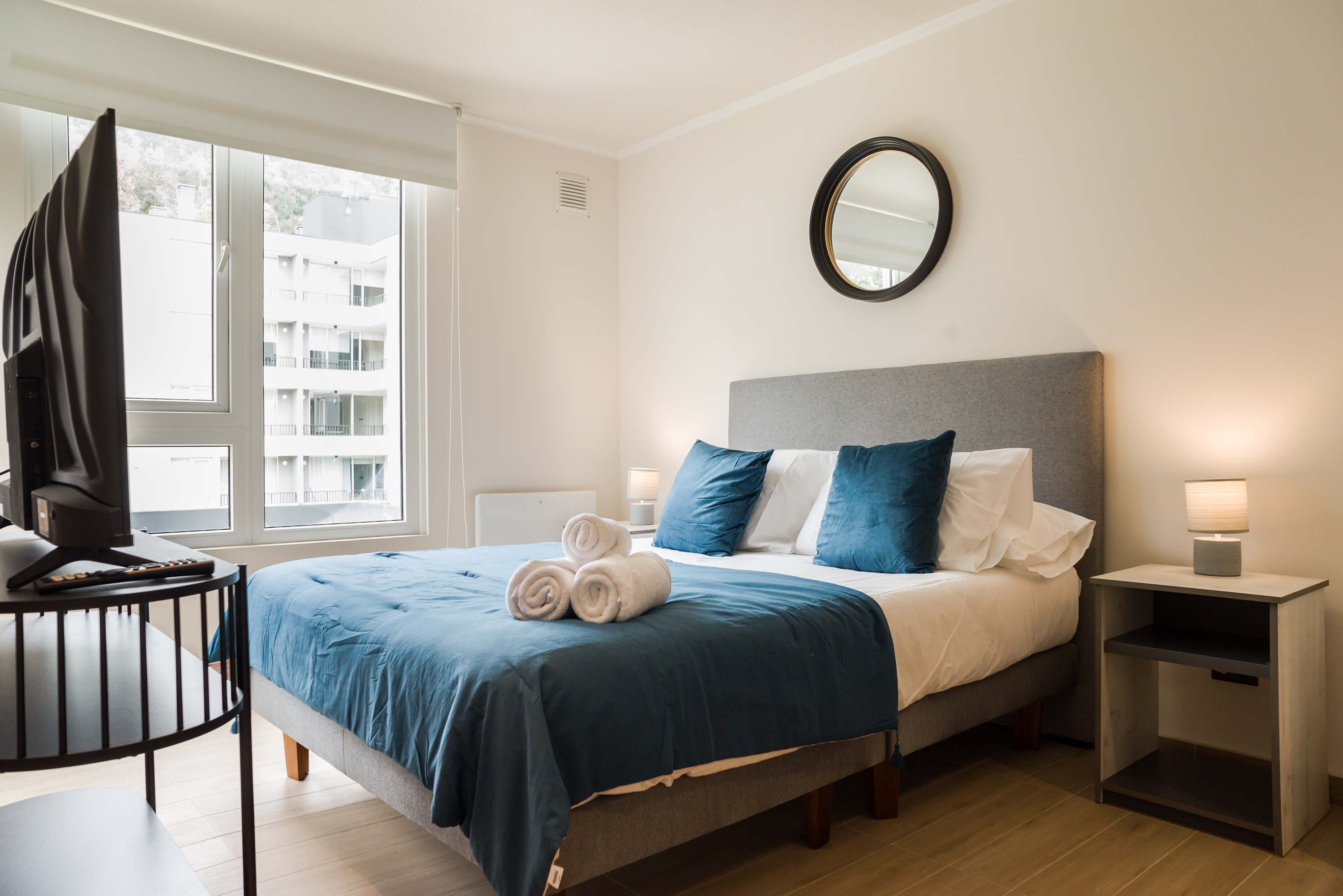 Relax in this bright and cozy bedroom with a comfy bed and modern decor, perfect for unwinding after a day of exploring.