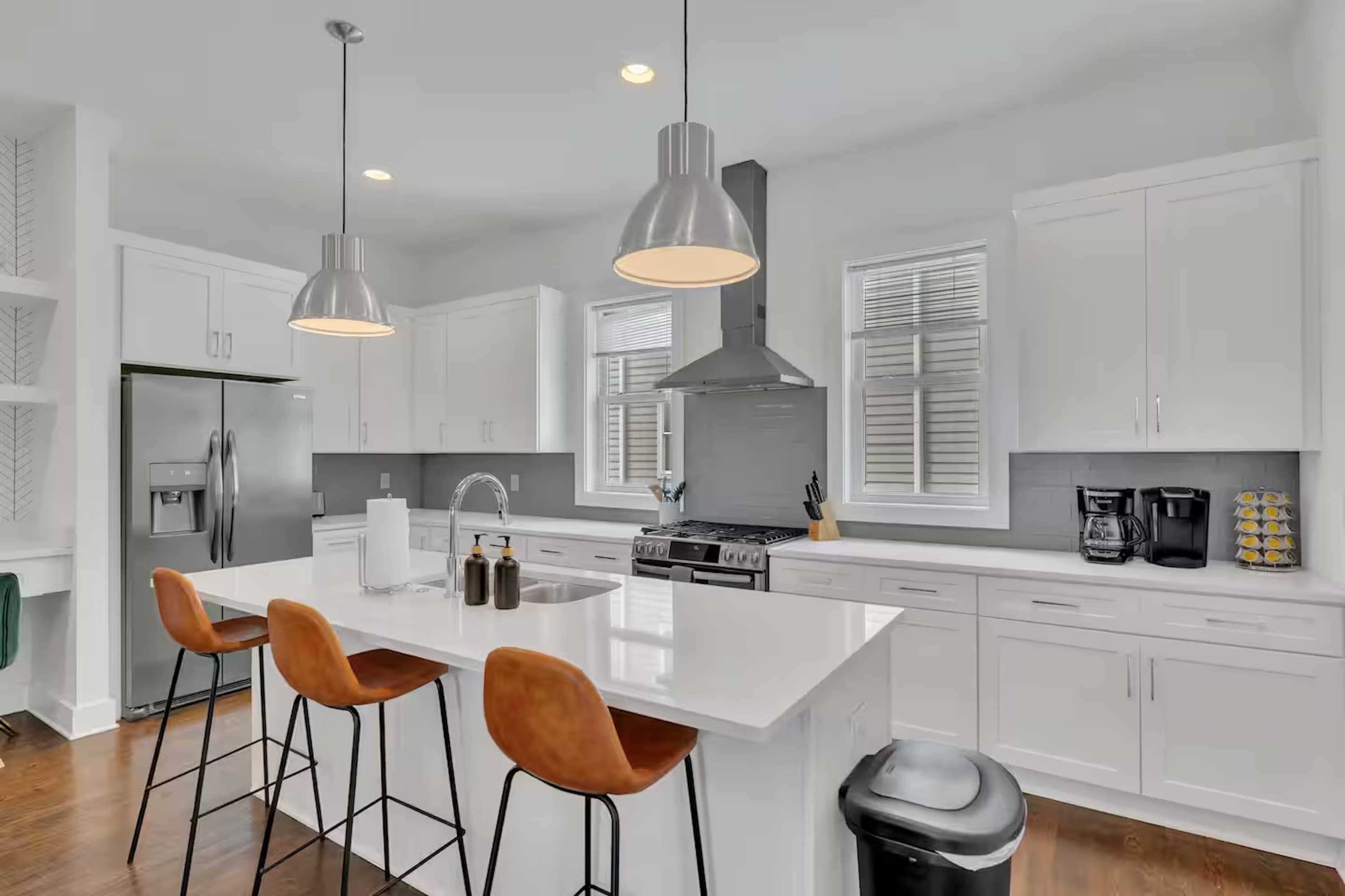 Open-concept kitchen with quartz counters, gas range, and stainless appliances. | Unit B