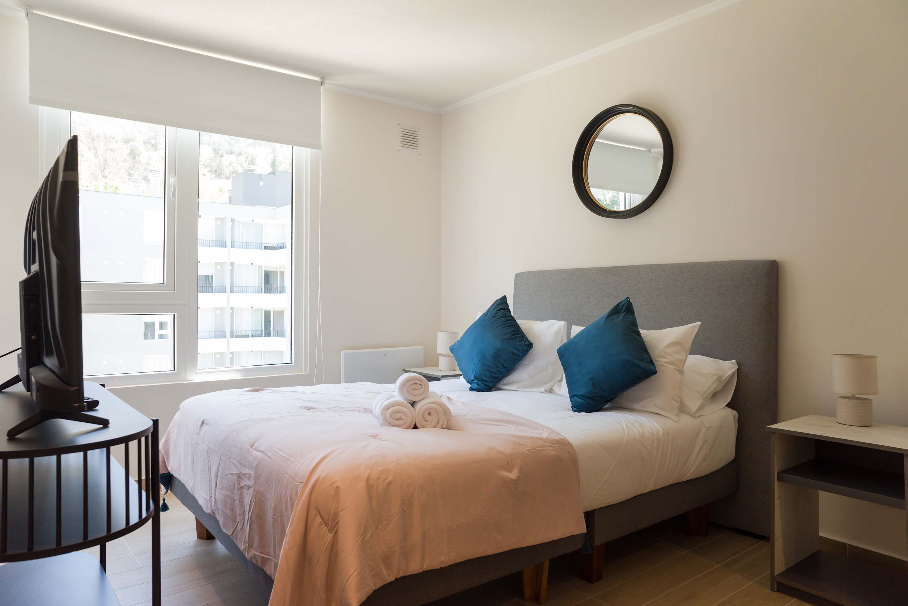 Cozy bedroom with natural light and modern decor, perfect for a restful stay.