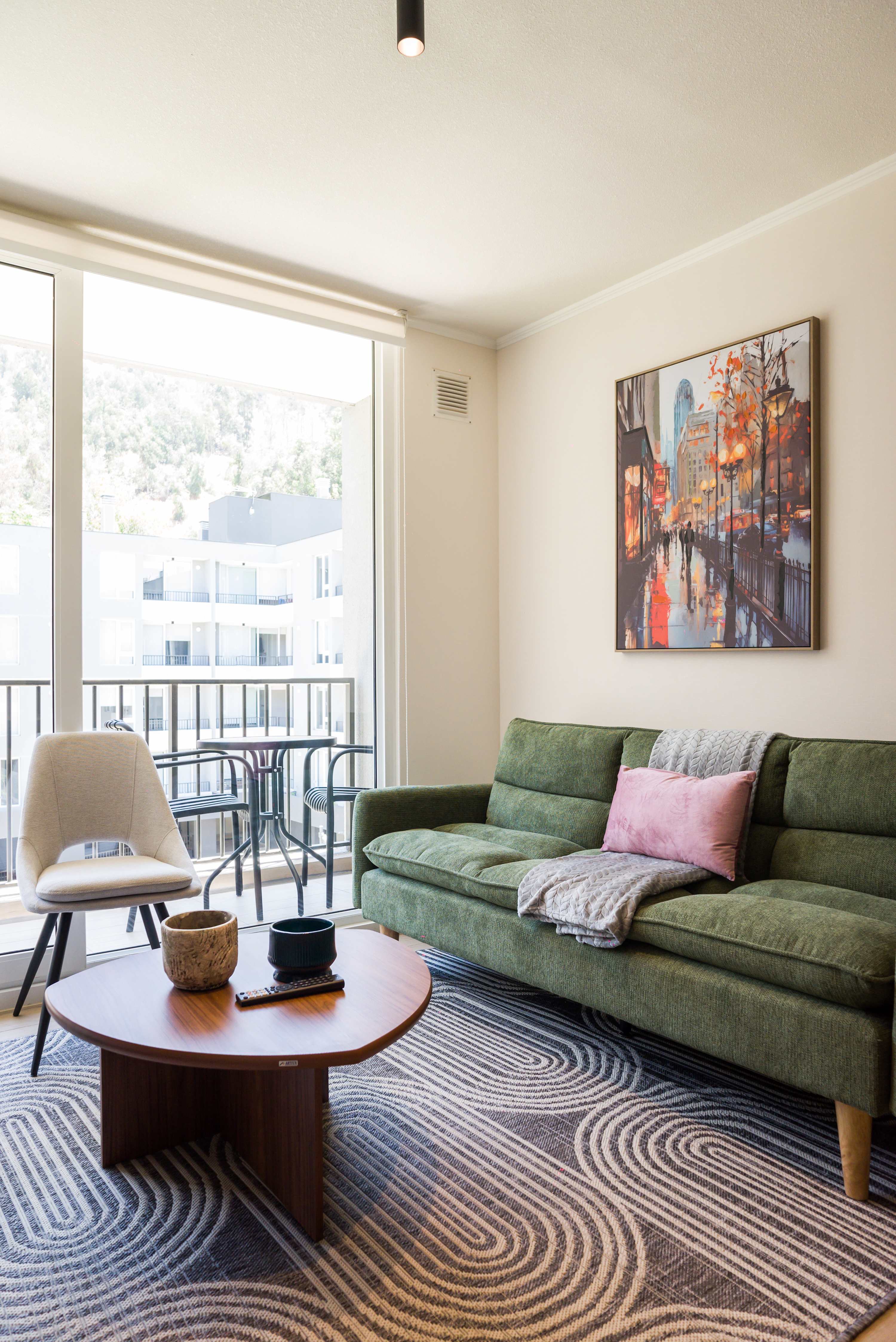 Cozy living room with stylish decor and a balcony view, perfect for relaxation in this Chilean apartment.