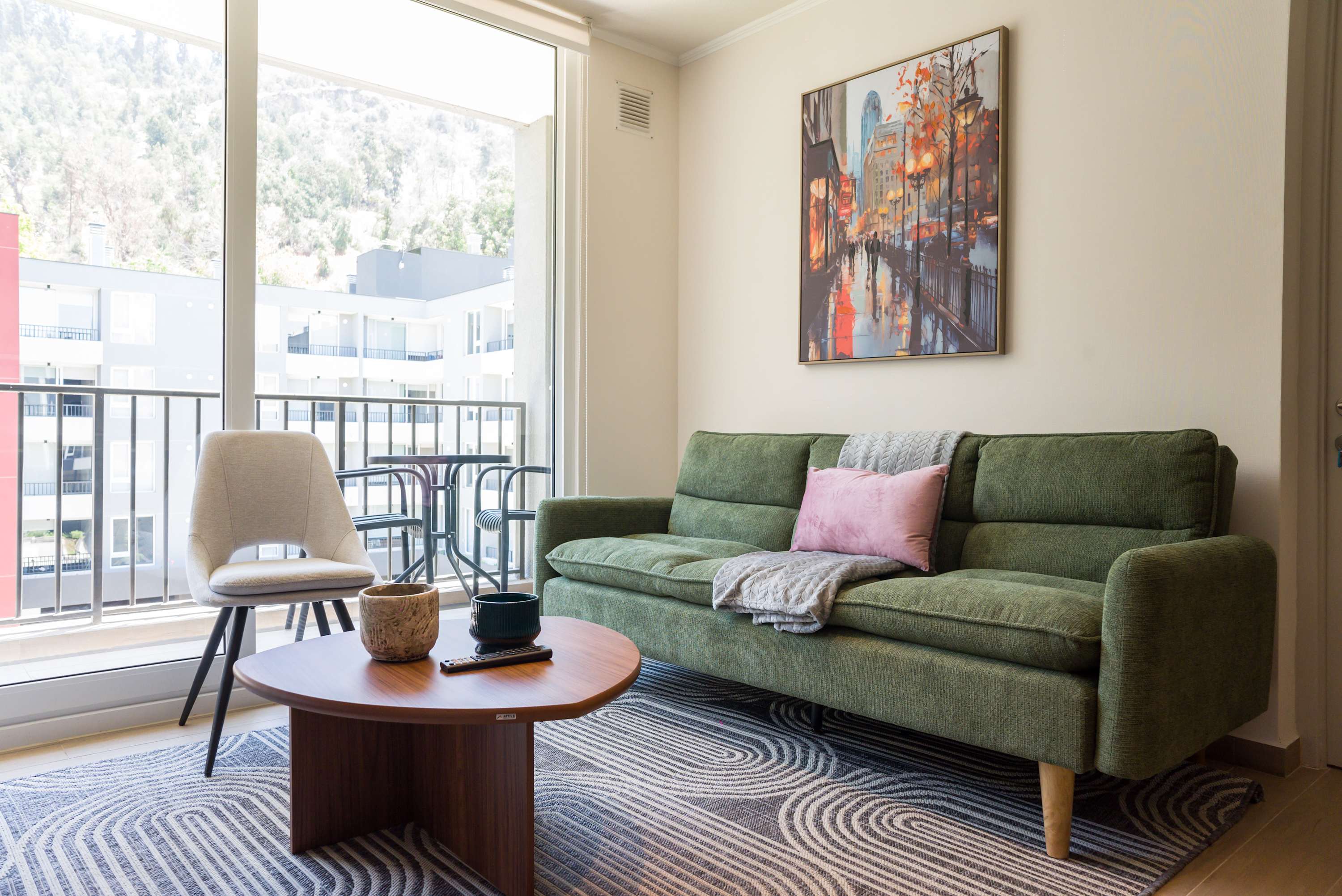 Relax in this stylish living room with a comfy sofa and vibrant cityscape art, perfect for unwinding after exploring the city.