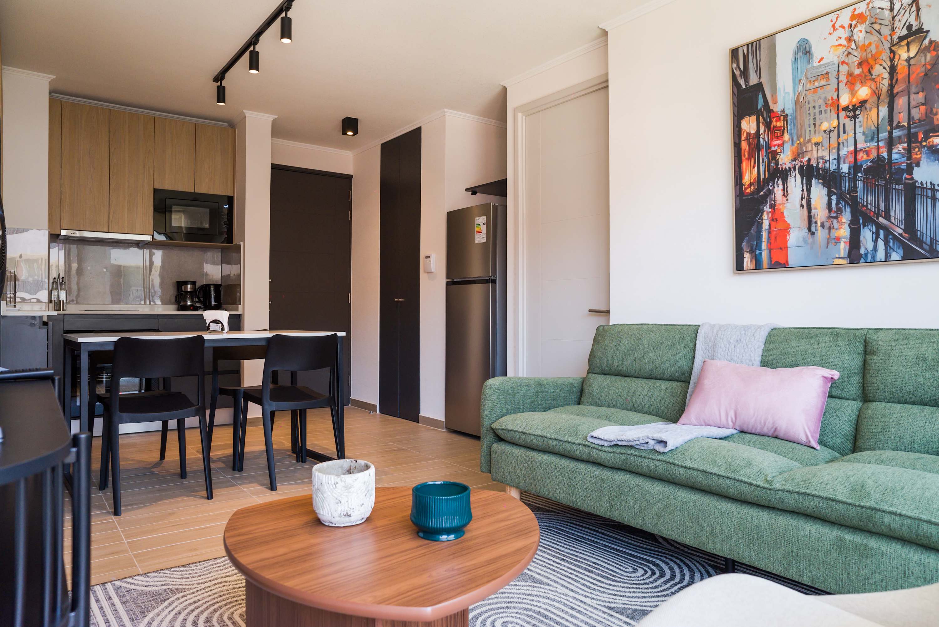 Cozy and modern living space with vibrant decor and a fully equipped kitchen, perfect for relaxing and dining.