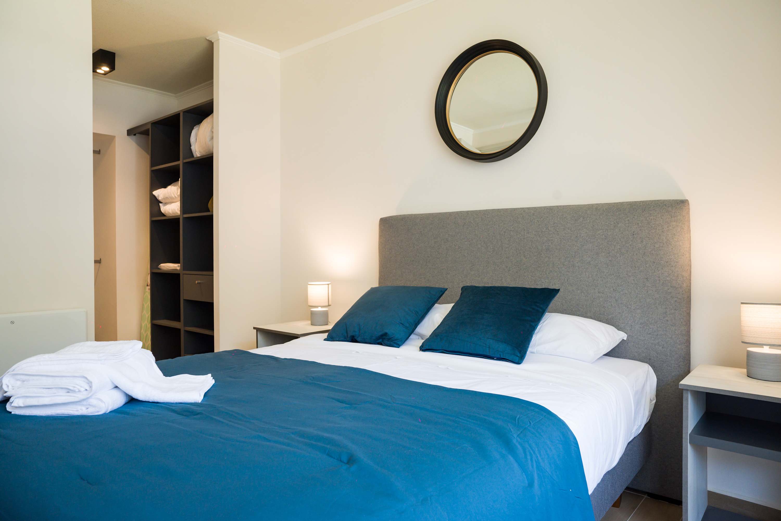 Cozy bedroom with plush bedding and ample storage, perfect for a restful stay.