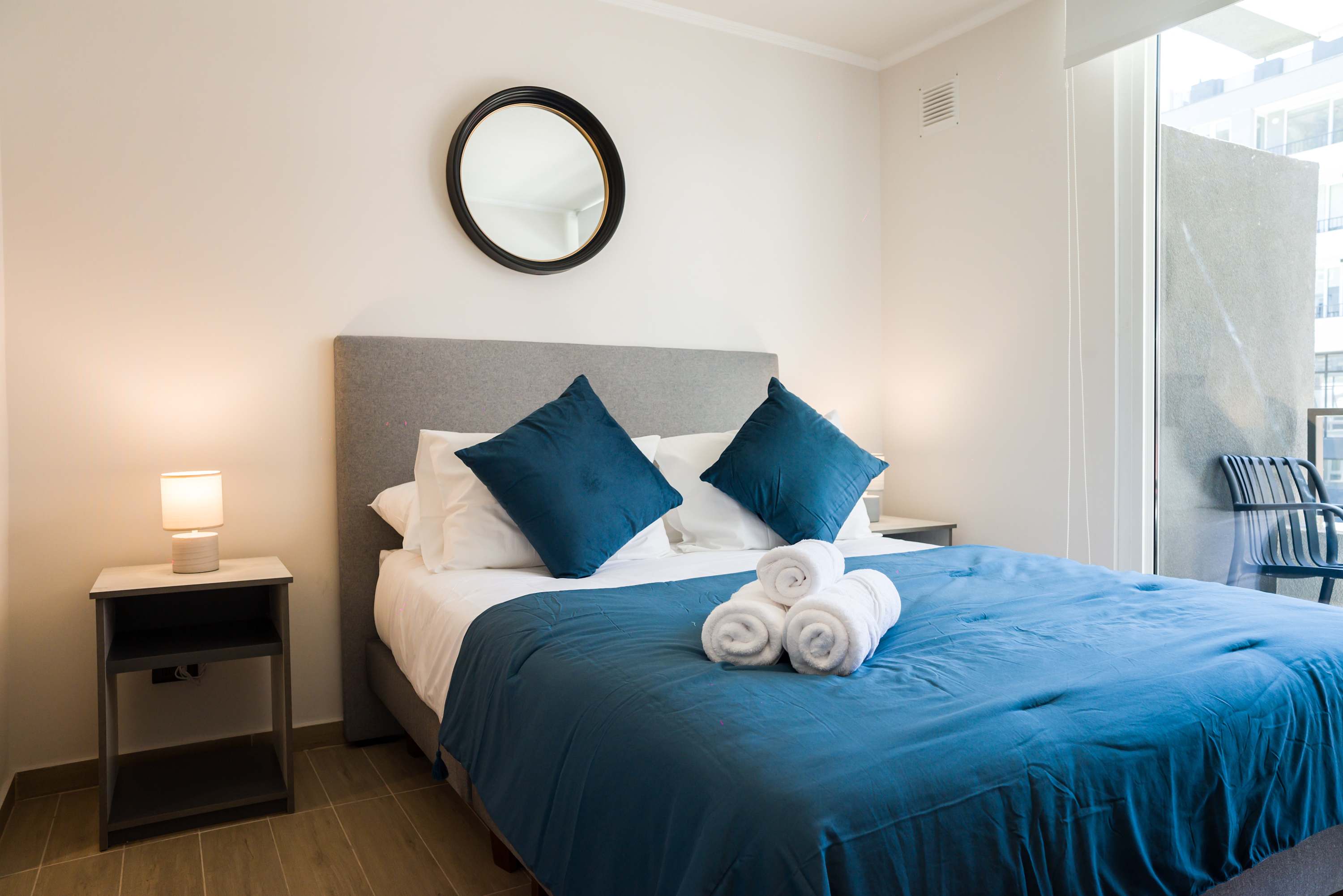 Relax in this cozy bedroom with a plush bed and private balcony access, perfect for unwinding after a day of exploring.