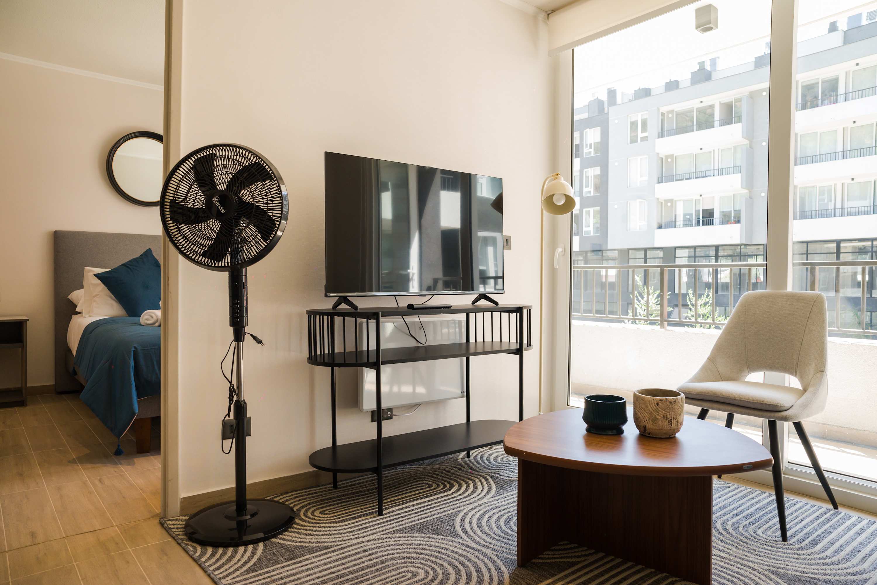 Bright and modern living area with a large TV and cozy seating, perfect for relaxation.