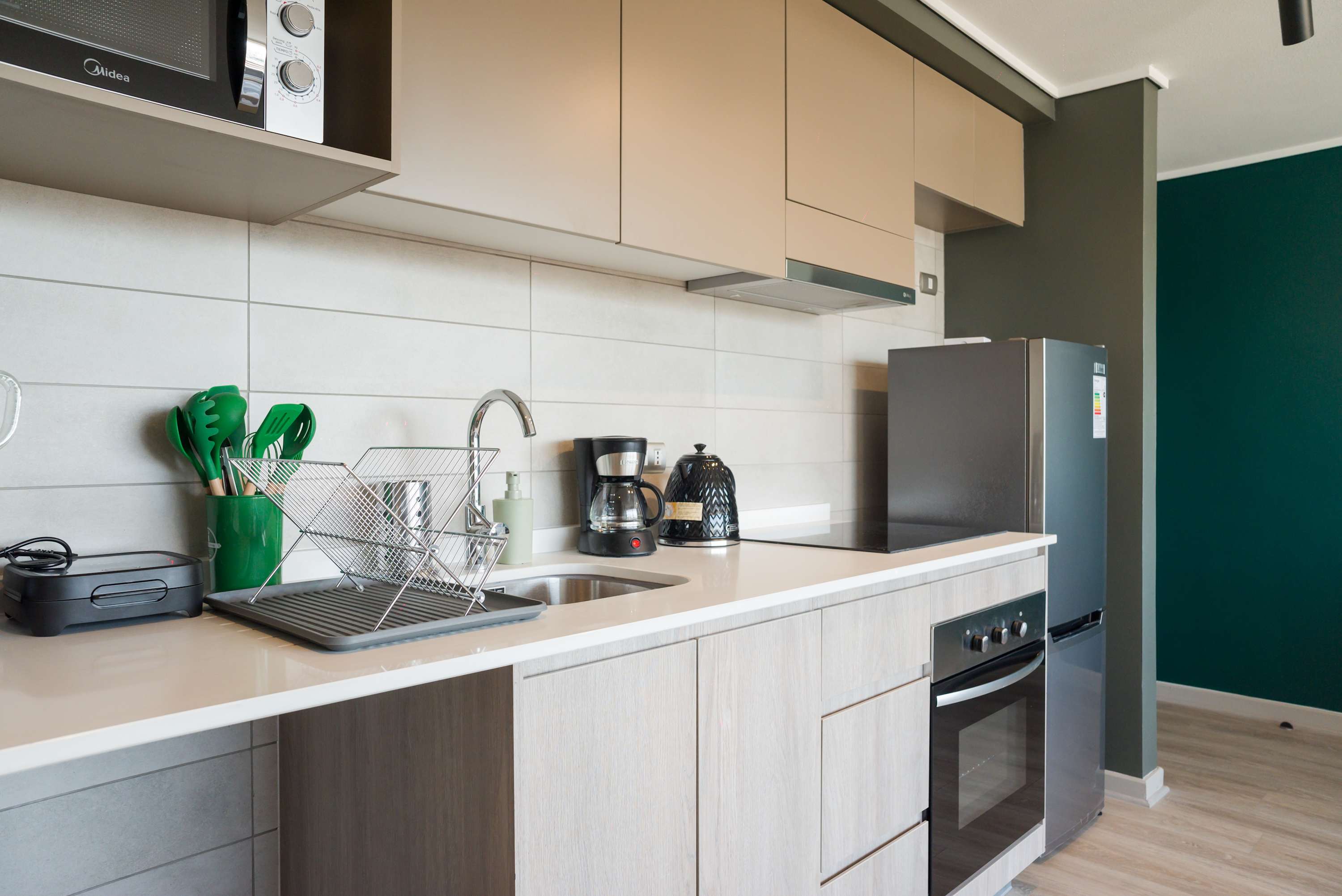 Sleek and modern kitchen with all essentials for a comfortable stay, featuring stainless steel appliances and stylish accents.