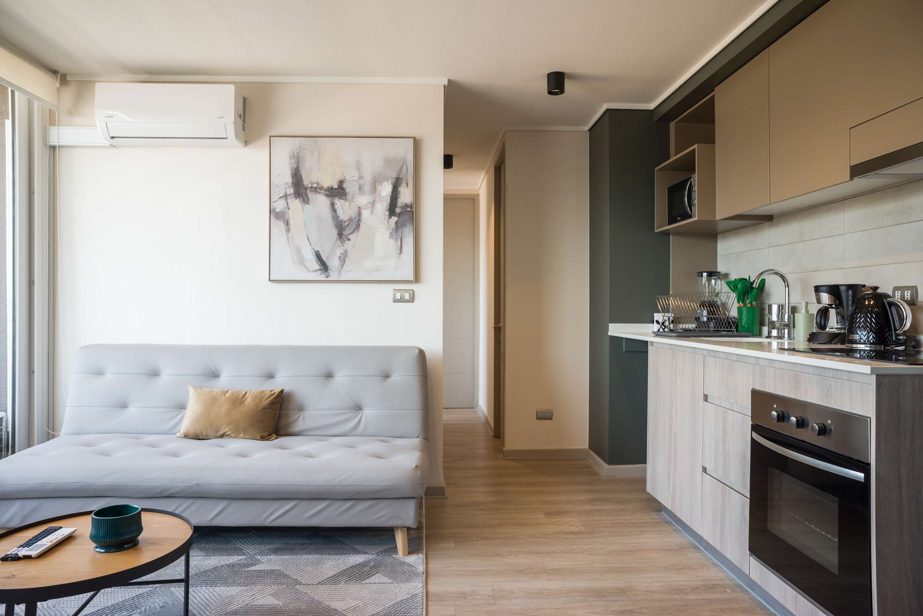 Modern and cozy living area with a sleek kitchenette, perfect for relaxing or cooking a meal after exploring the city.