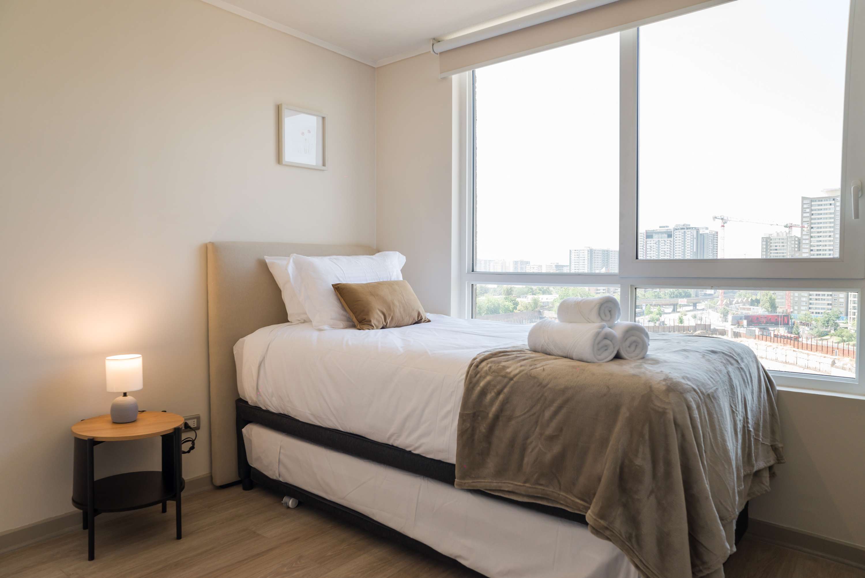 Cozy bedroom with stunning city views, perfect for relaxation after a day of exploring.