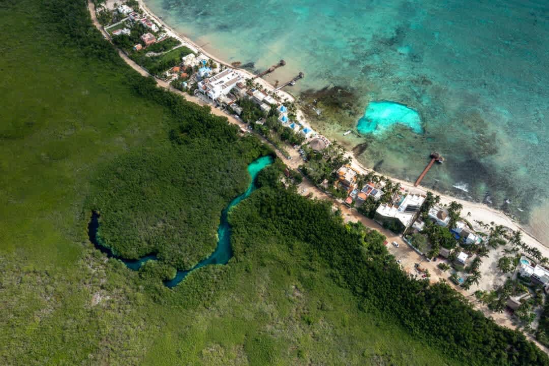 Enjoy a stunning drone view over Tankah Bay, where turquoise sea views meet the vibrant reef barrier—ideal for diving and snorkeling. The area also features Casa Cenote, one of Tulum’s most beautiful cenotes, uniquely known for its rare blend of fres