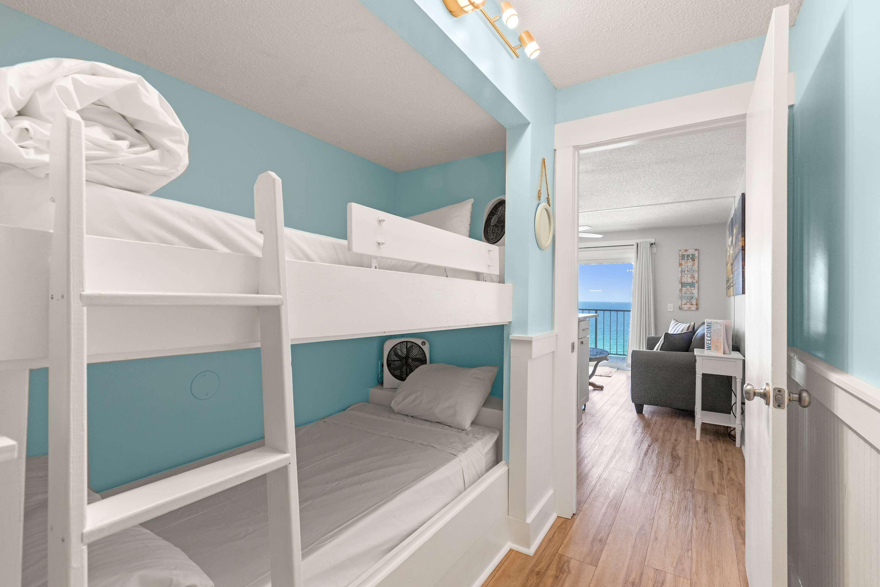 The Summit 1419 – Bunk beds in a bright room, view of the ocean visible through an open doorway.