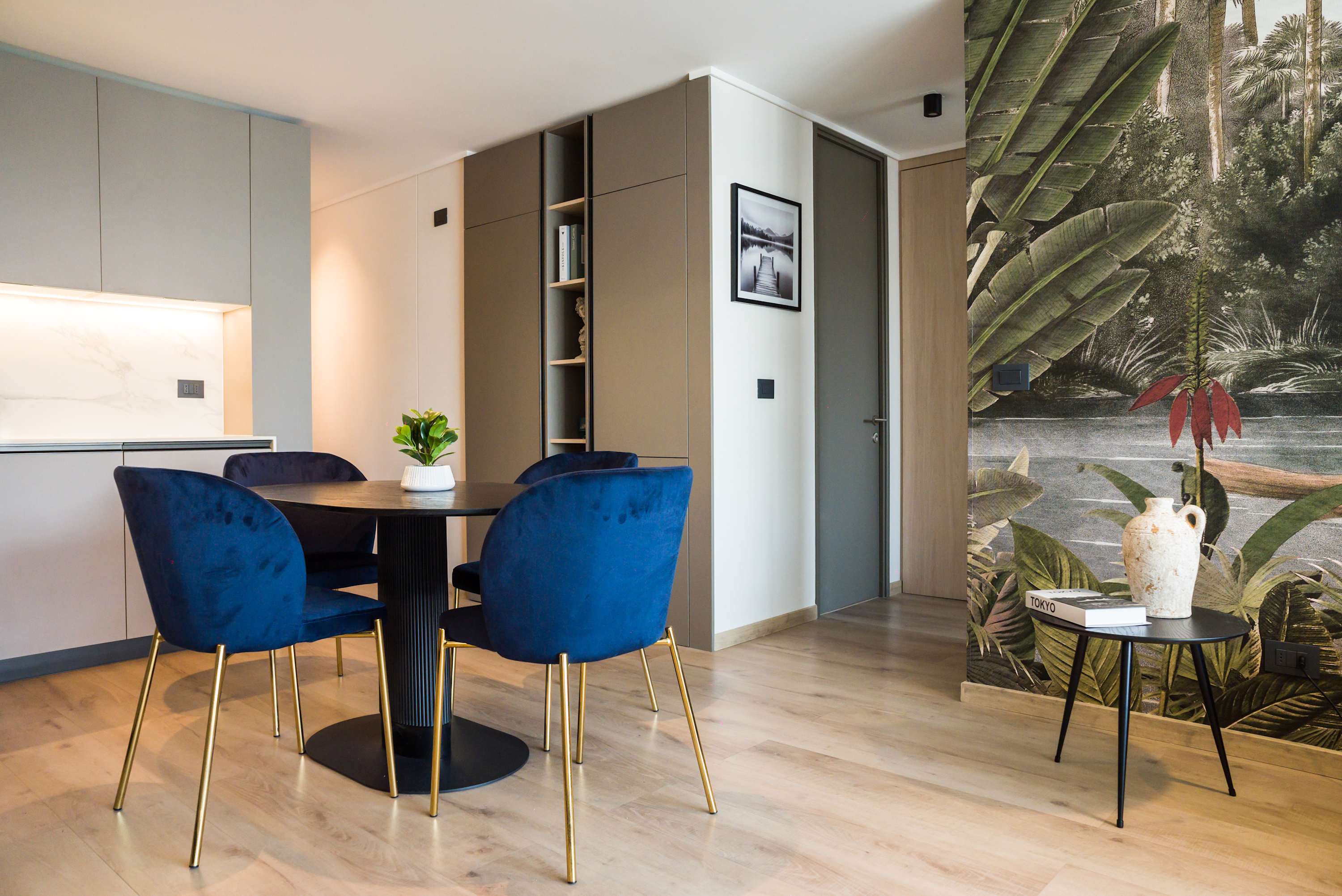 Stylish dining area with vibrant blue chairs and a stunning mural, perfect for intimate meals.